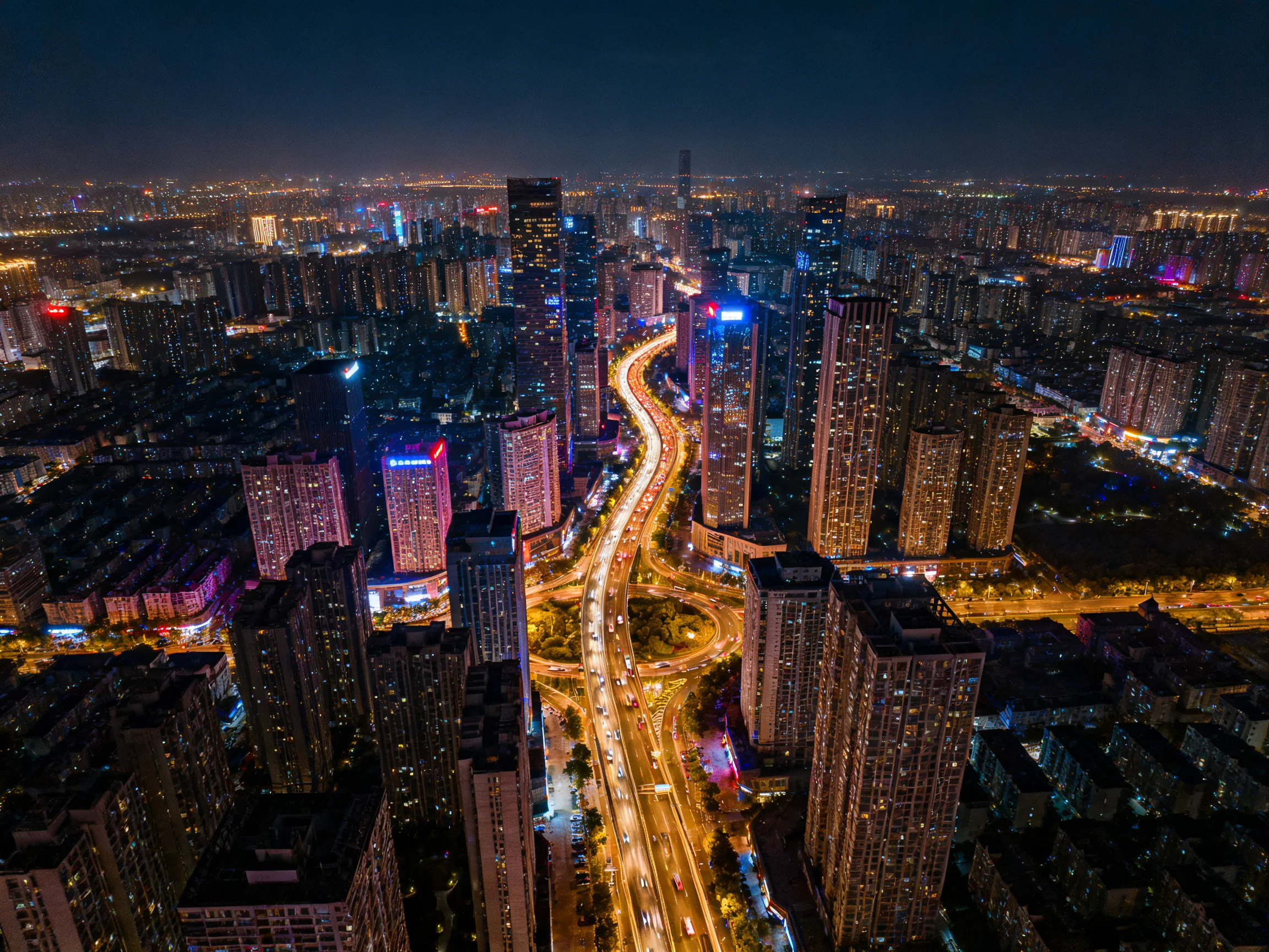 Vibrant nighttime cityscape featuring multicolored lit skyscrapers