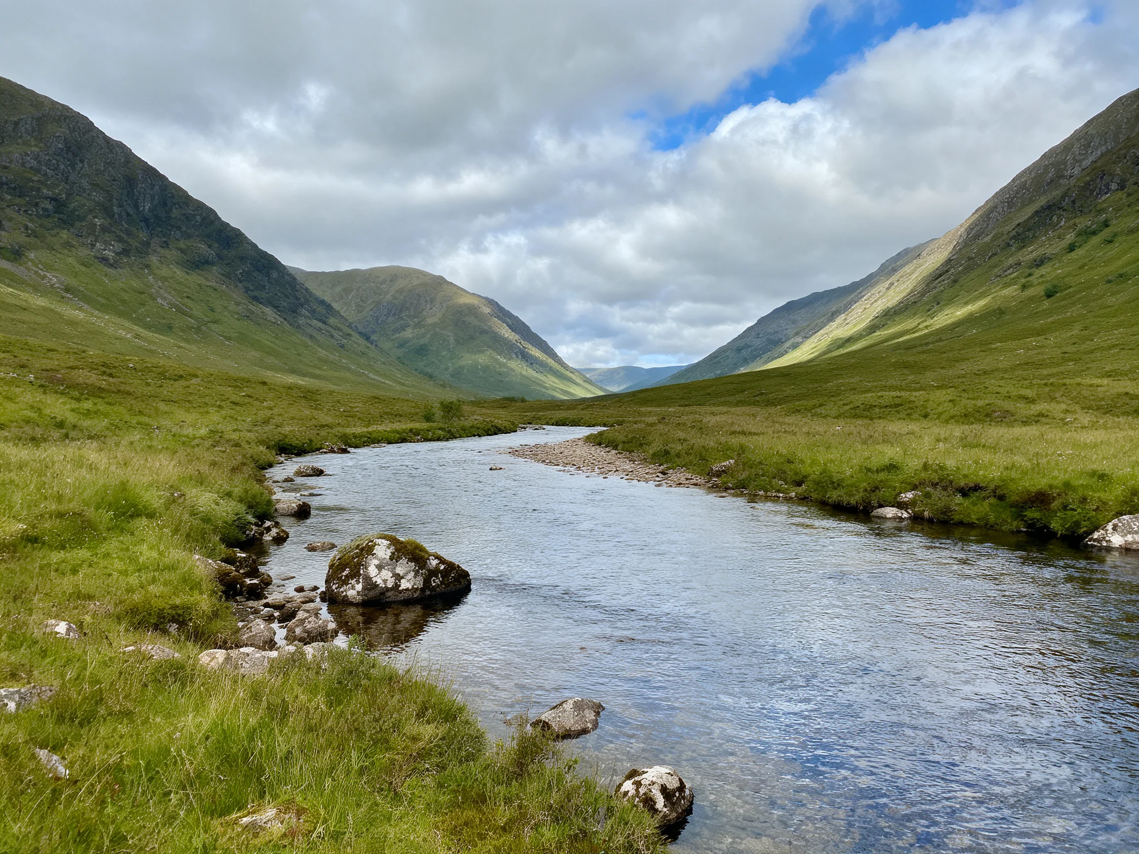 A serene river winds through lush green valleys between towering mountains