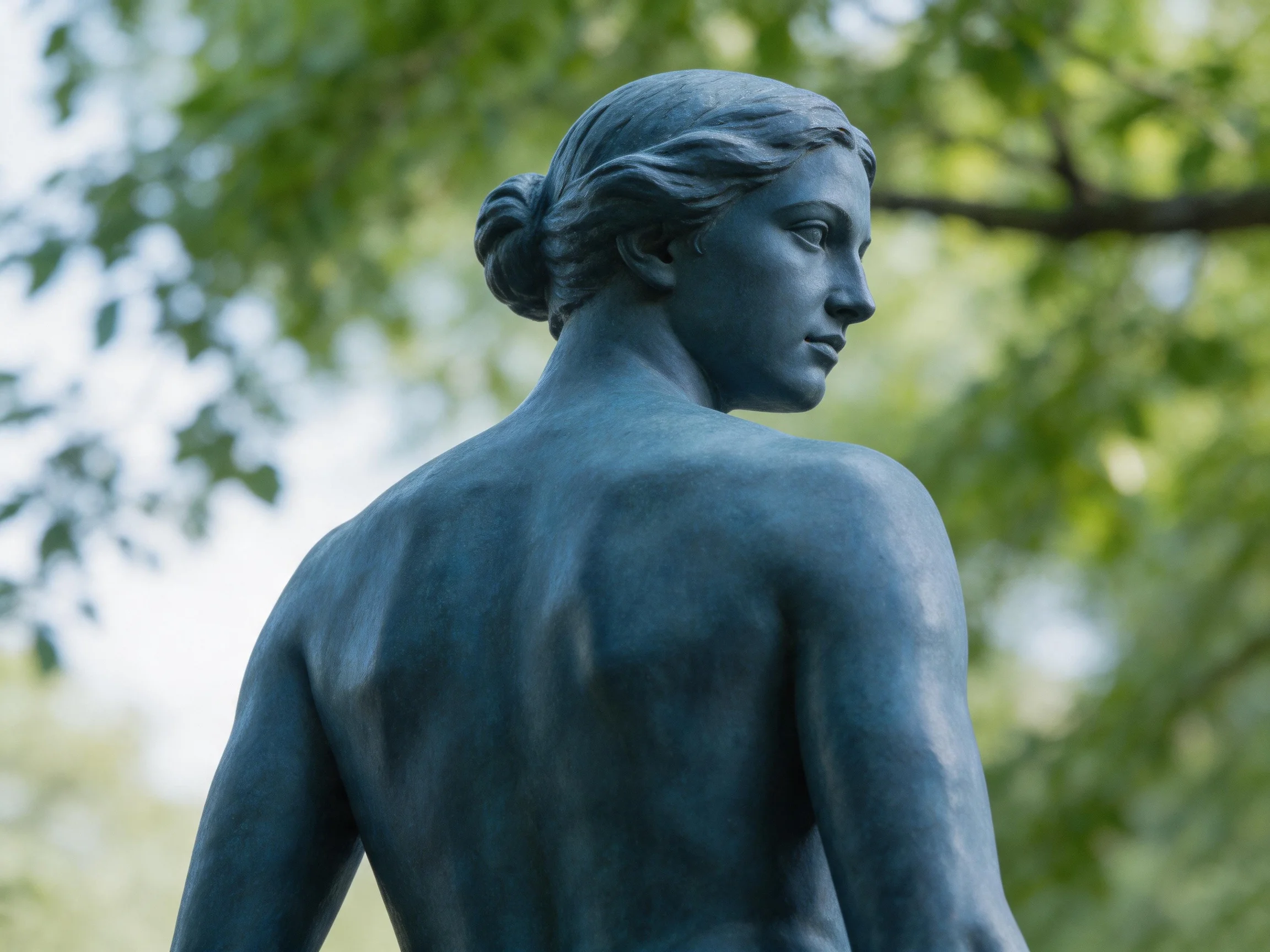 A Blue-Toned Female Statue in a Lush Green Park Setting