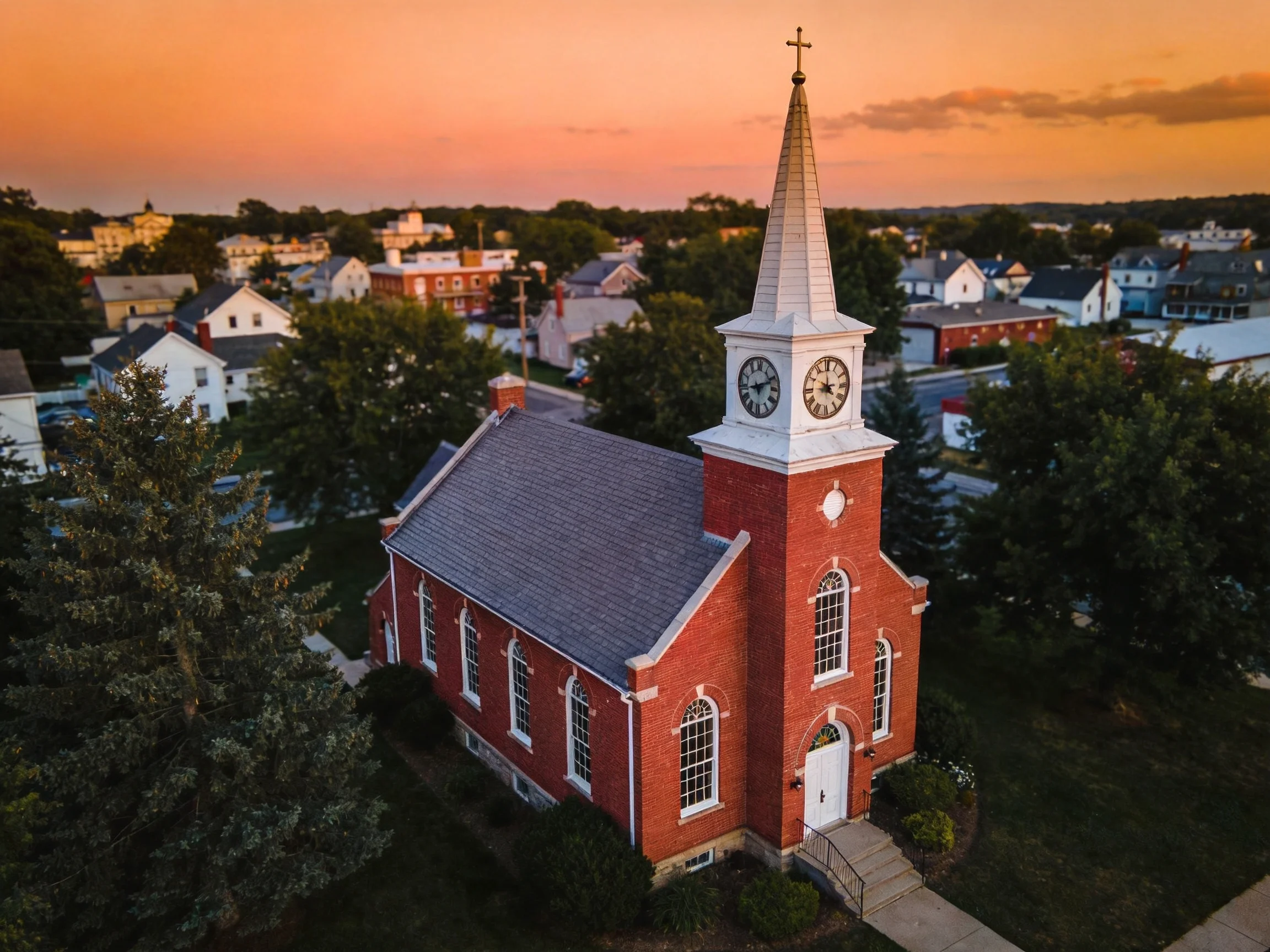 A Red Brick Church with Clock Tower at Sunset