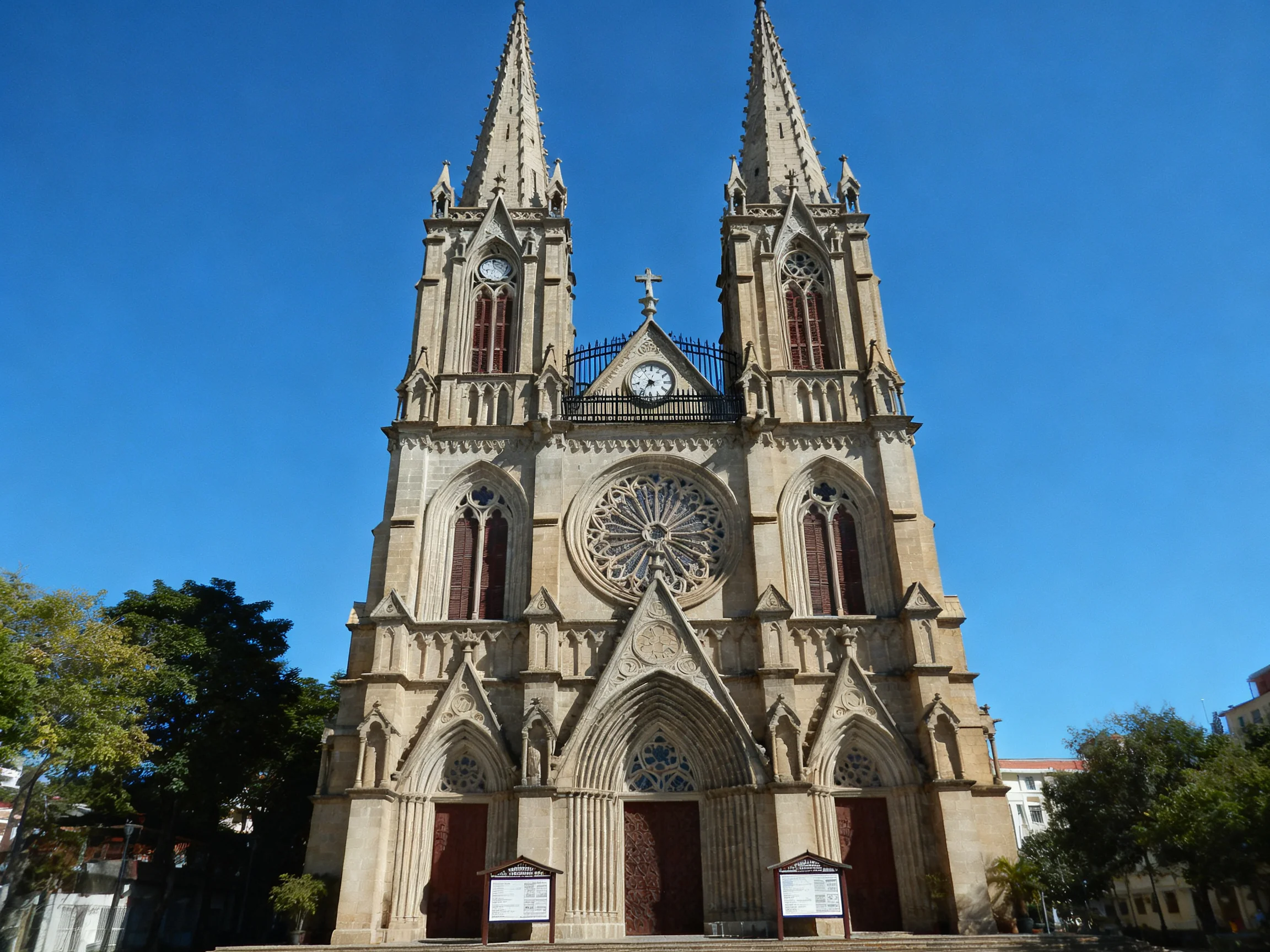 A grand Gothic-style cathedral with twin spires under clear blue sky