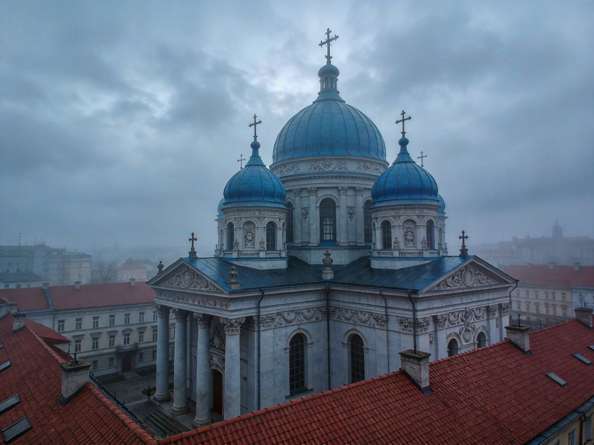 A grand church with three blue domes amid red-roofed buildings