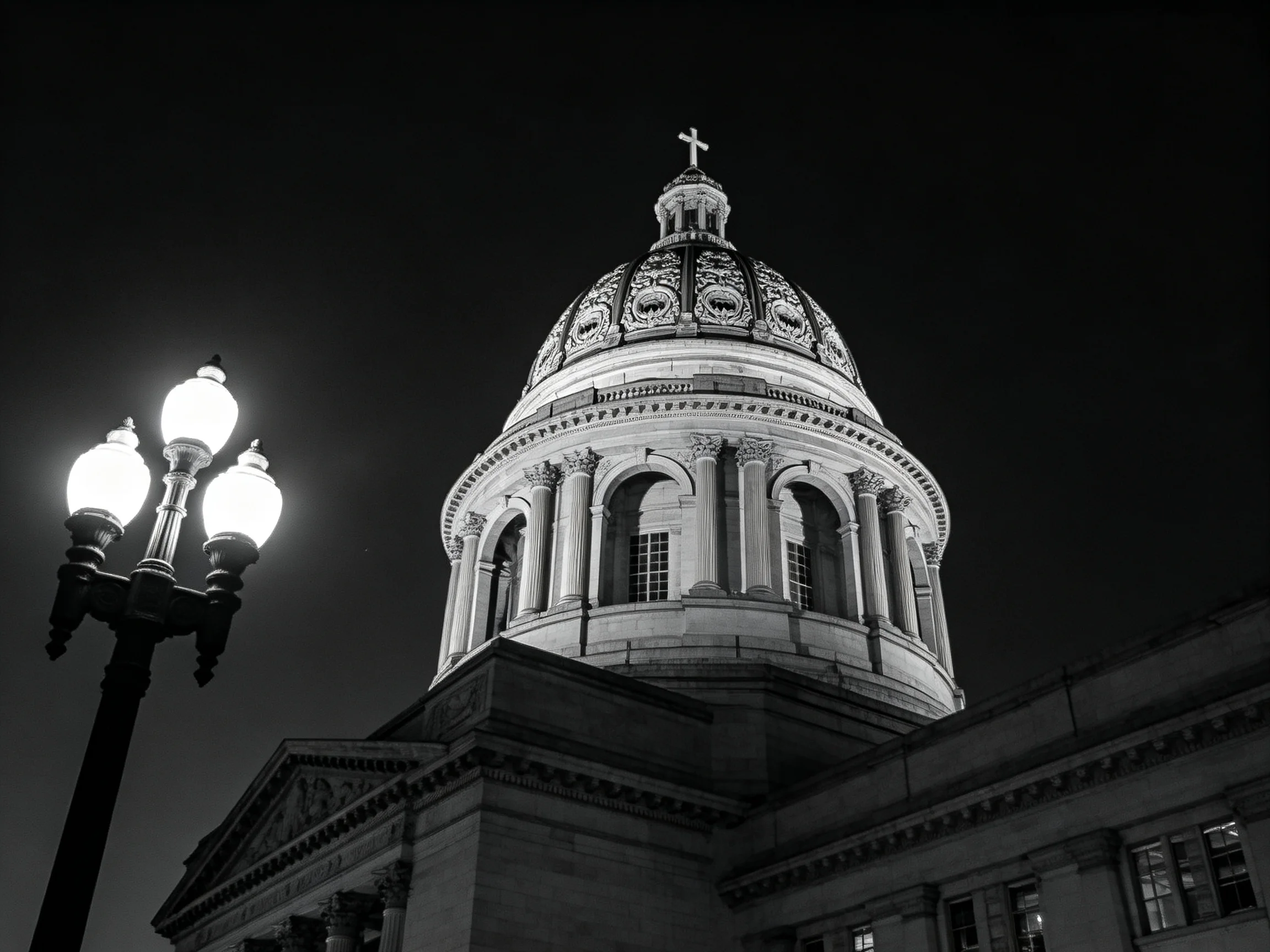 A grand domed building with ornate architectural details beside glowing street lamps