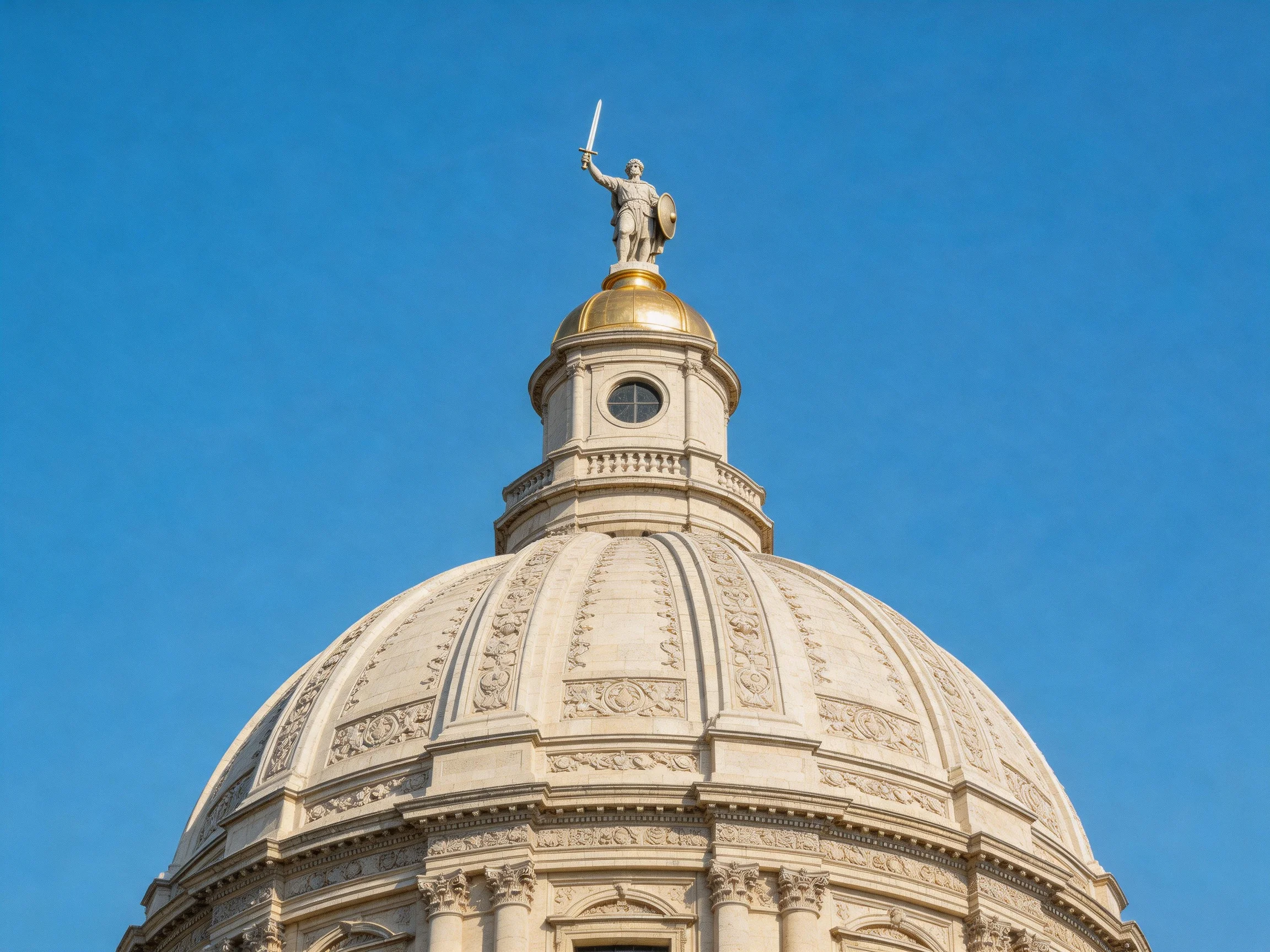 A grand stone dome topped with a golden warrior statue under a clear blue sky
