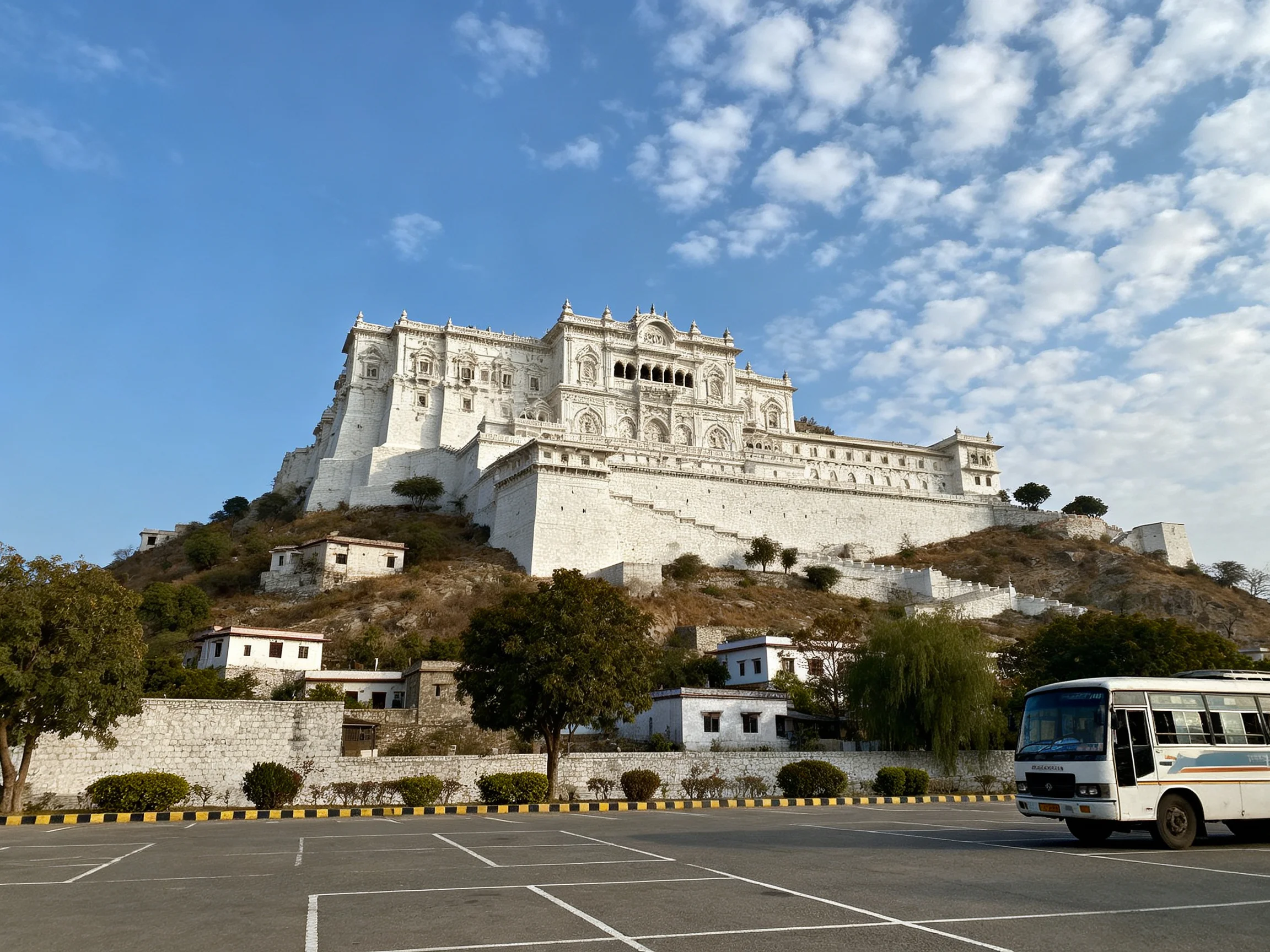 A grand white fortress atop a hillside under bright blue skies