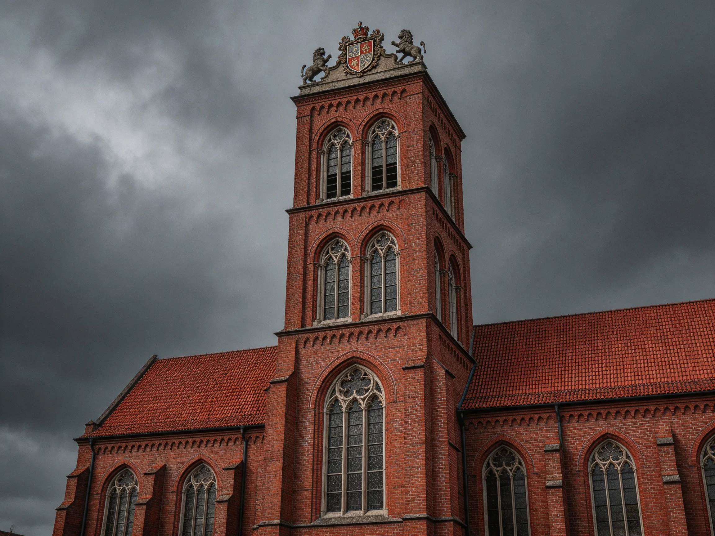 A historic red-brick church tower against stormy skies