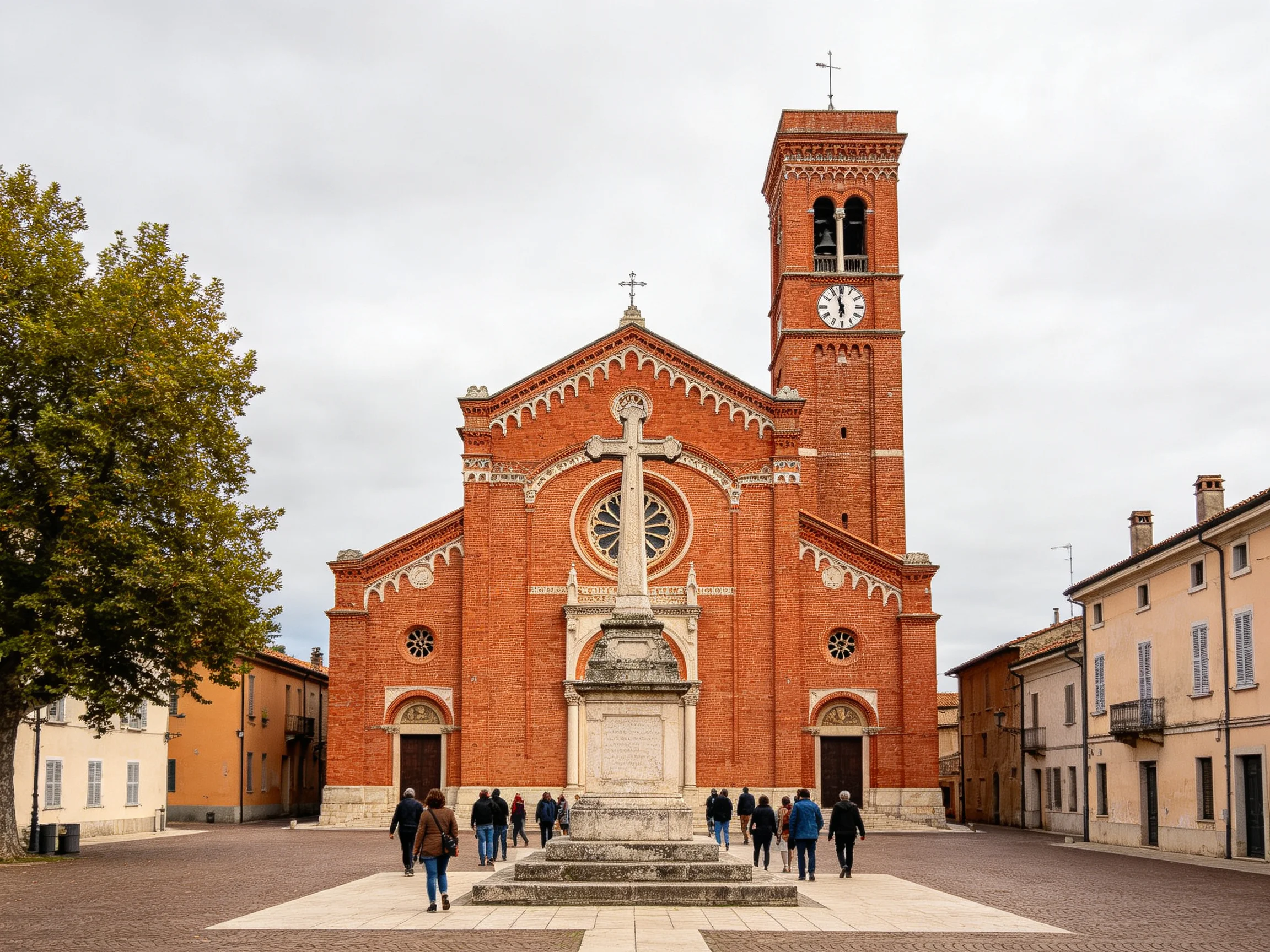 A historic red-brick church with a tall clock tower in a town square