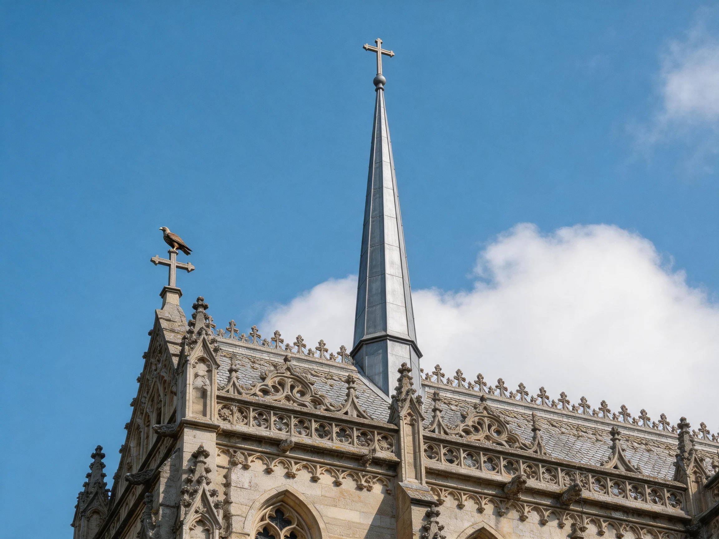 A historic stone church with tall spires and ornate carvings under bright blue sky