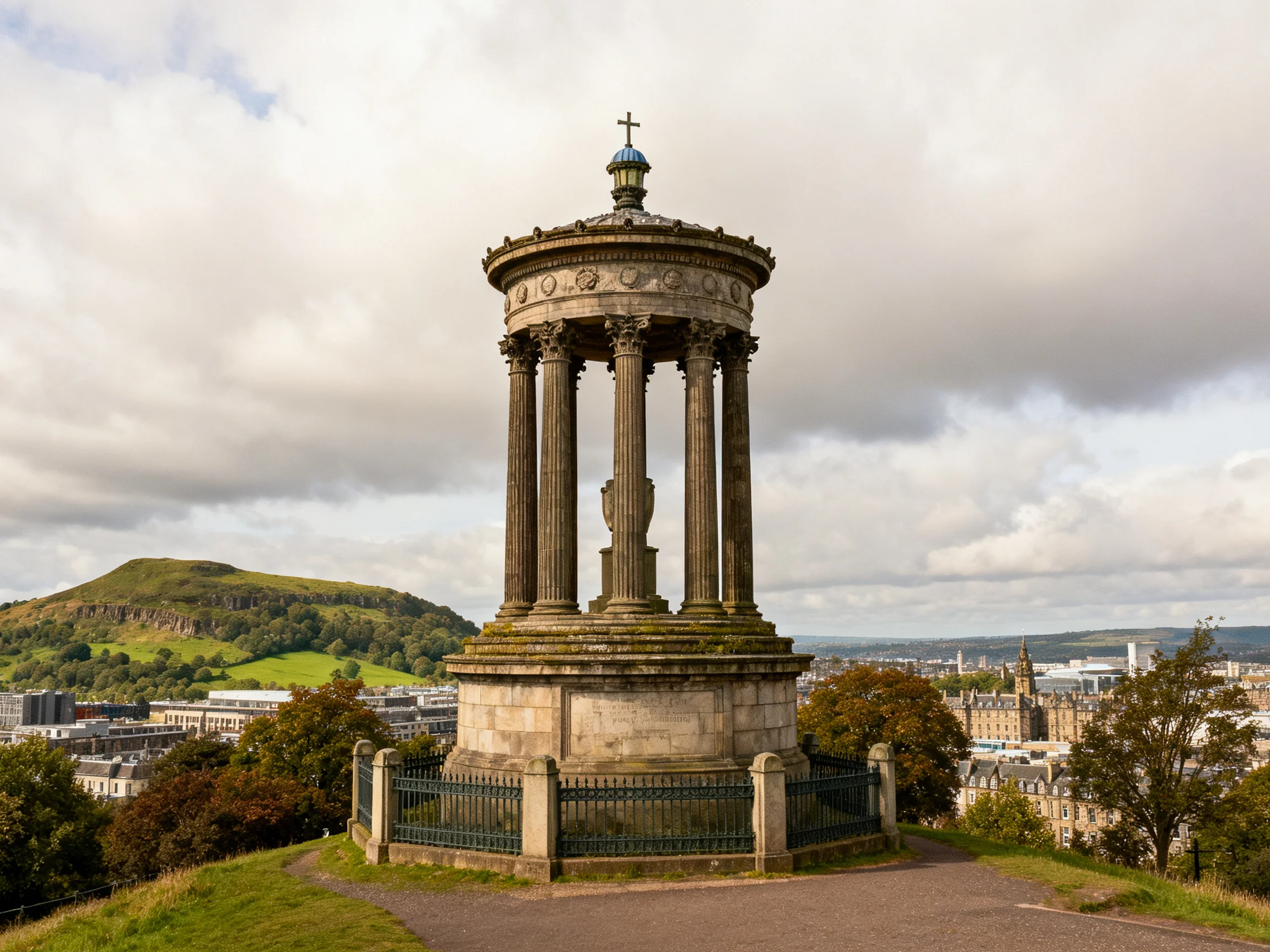 A historic stone columned monument overlooks Edinburghs cityscape