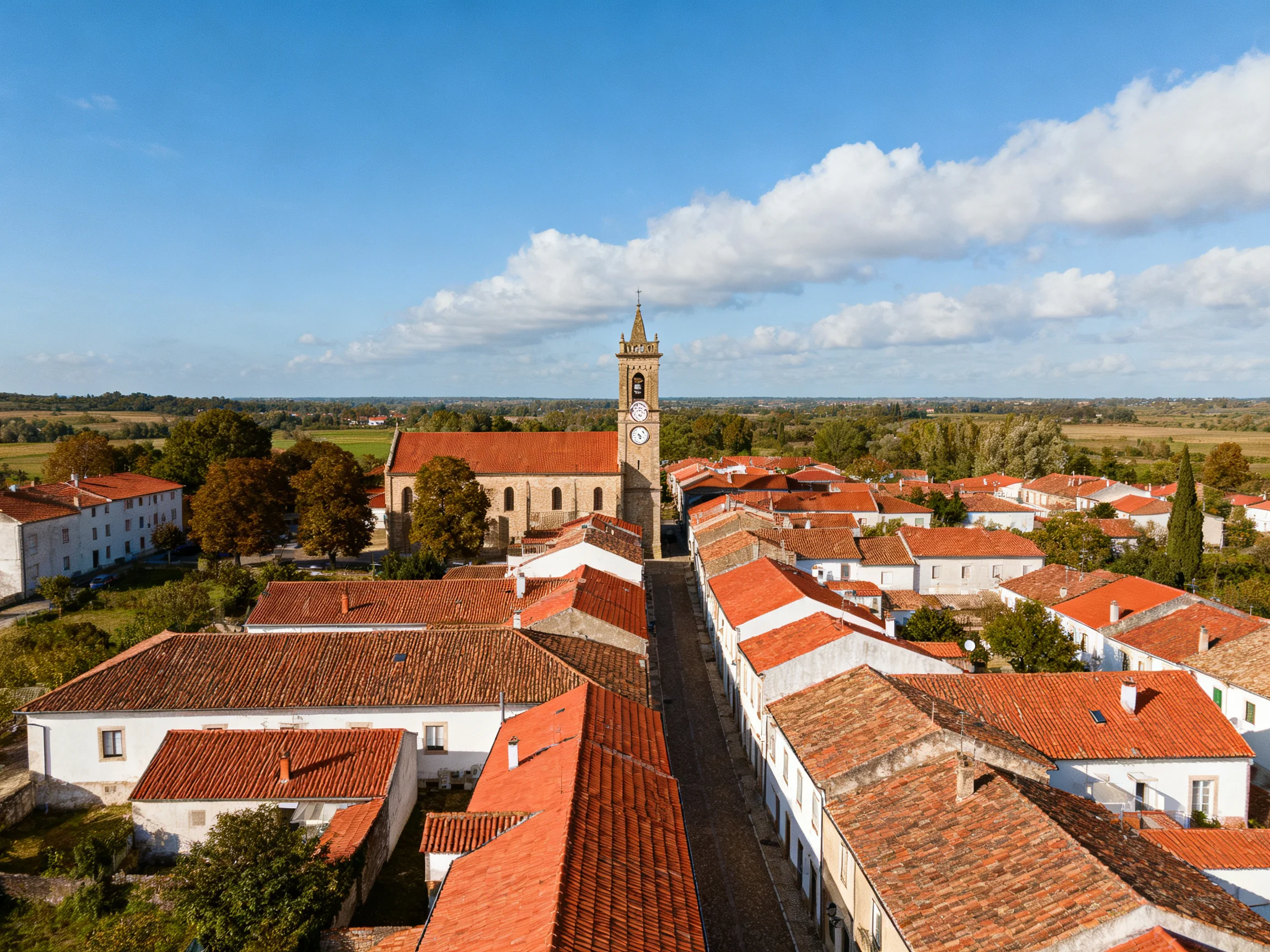 A historic village with red - tiled roofs and a central clock tower