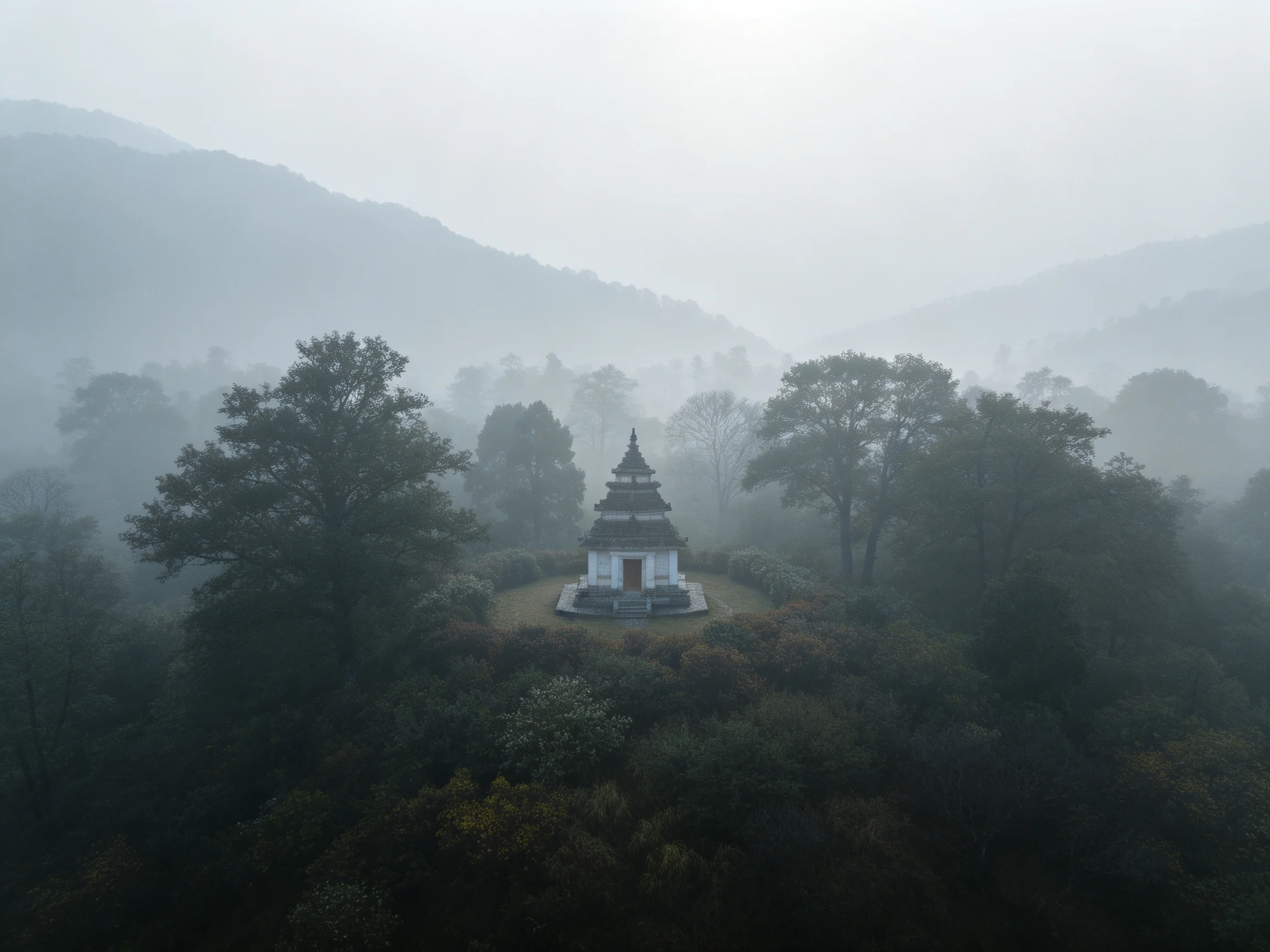 A small white pagoda amidst misty forest and rolling hills