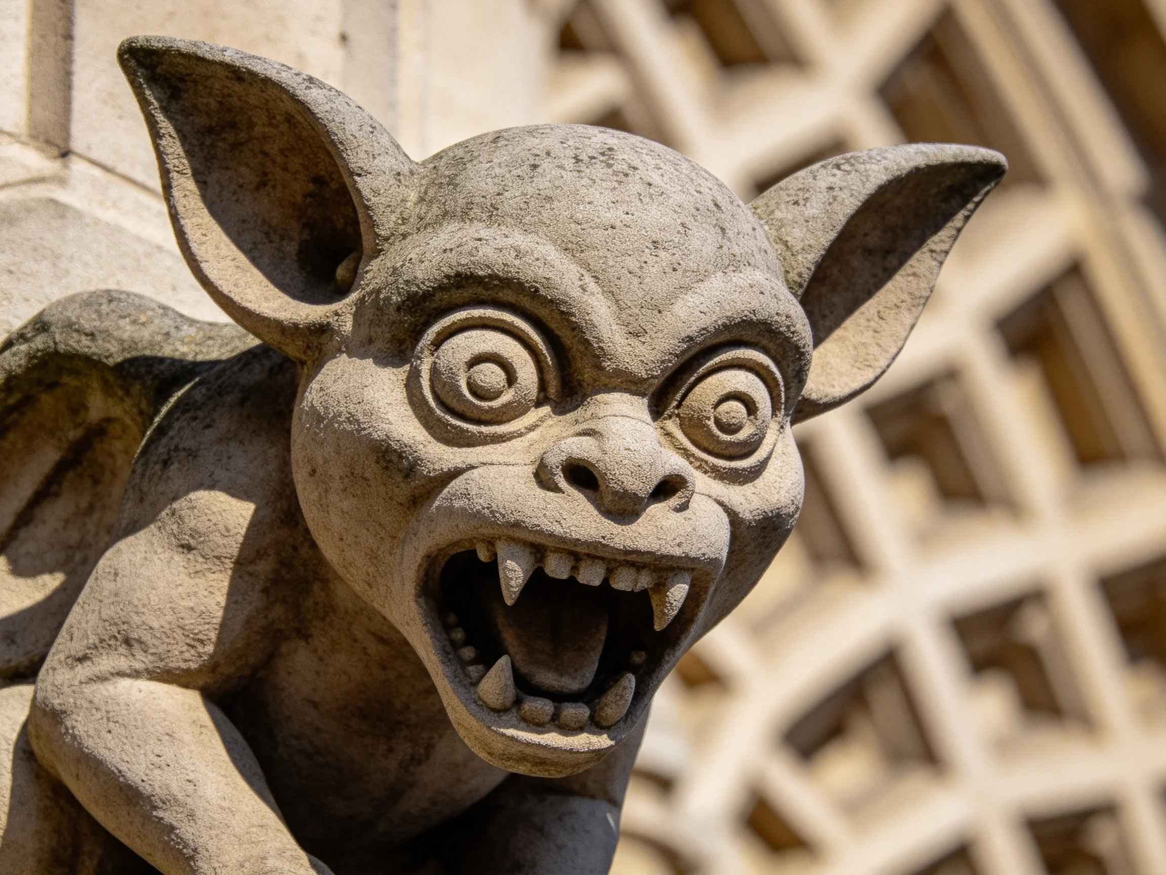 A stone gargoyle statue with exaggerated ears and menacing expression