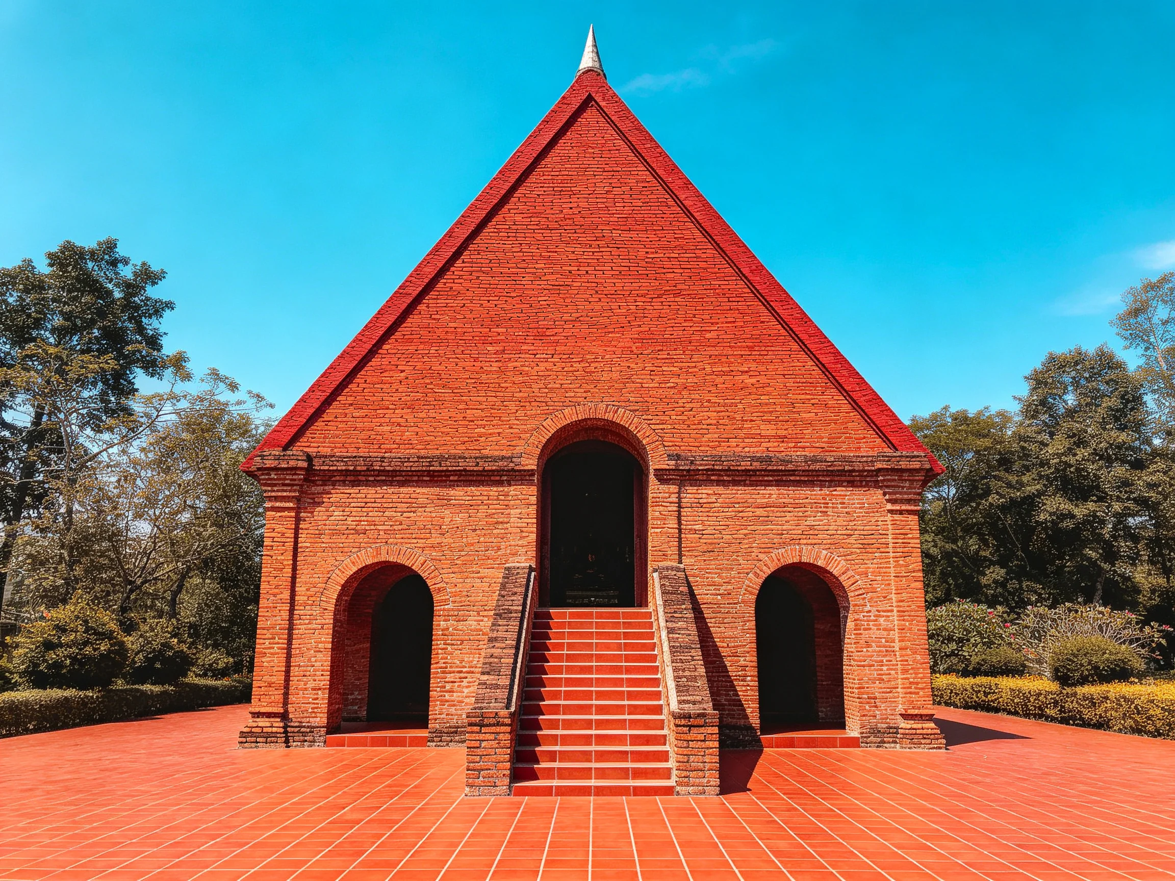 A striking red-brick chapel with triangular roof and arched entrances