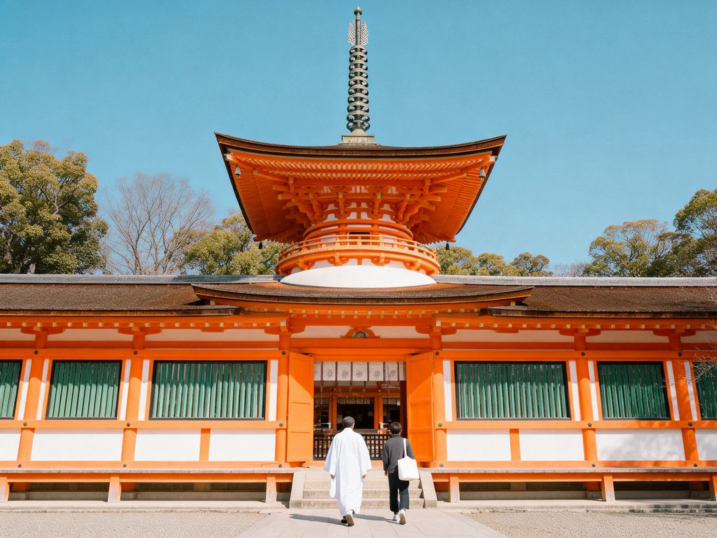 A traditional orange temple with a pagoda tower, two visitors approach