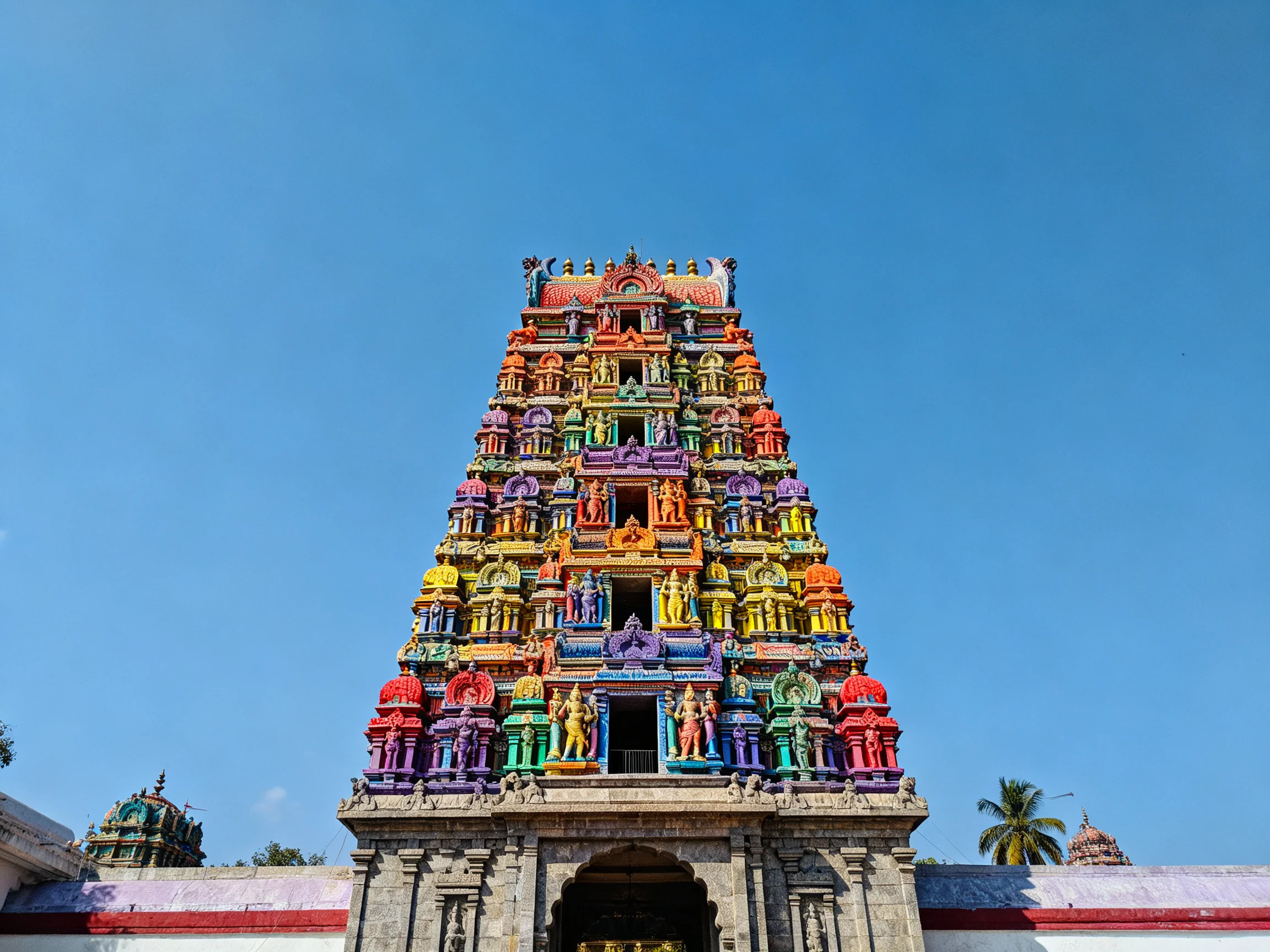 A vibrantly painted traditional temple tower with intricate carvings
