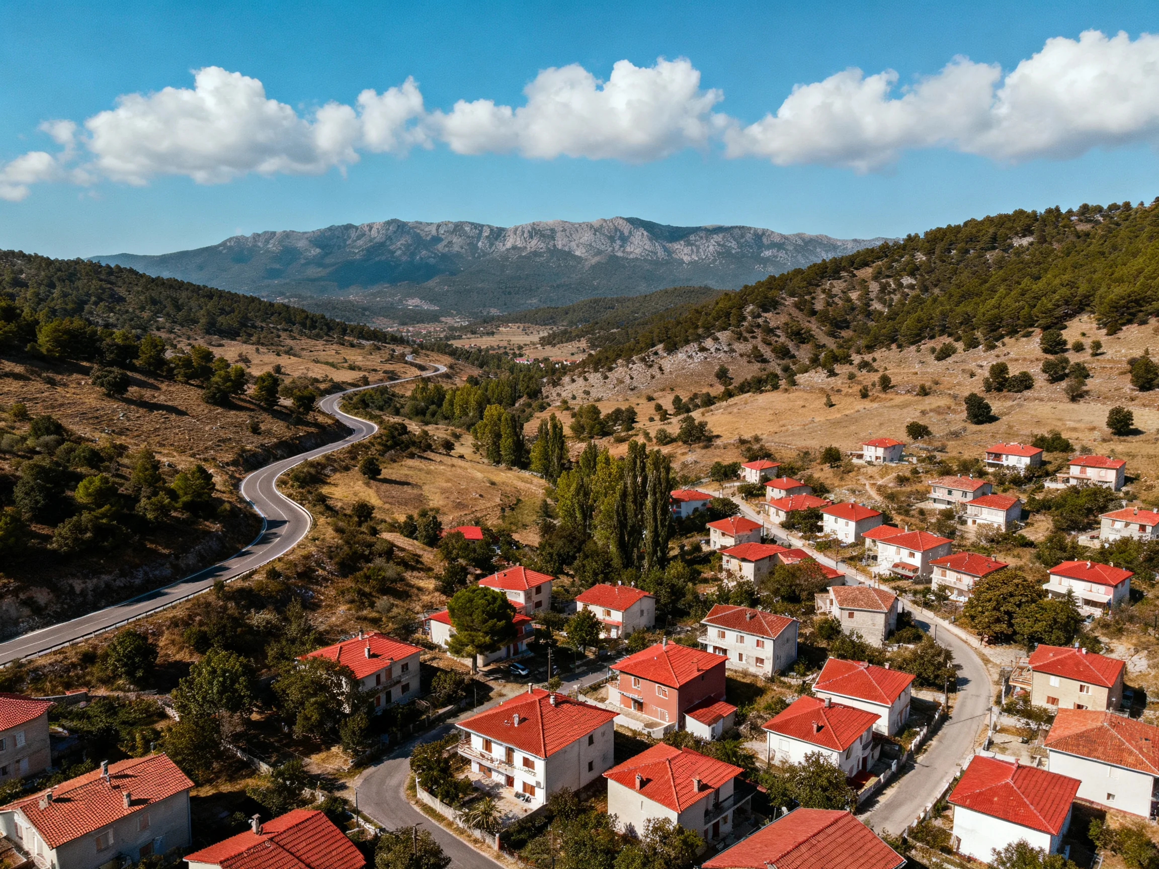 A village of red-roofed homes nestled among rolling hills and mountains