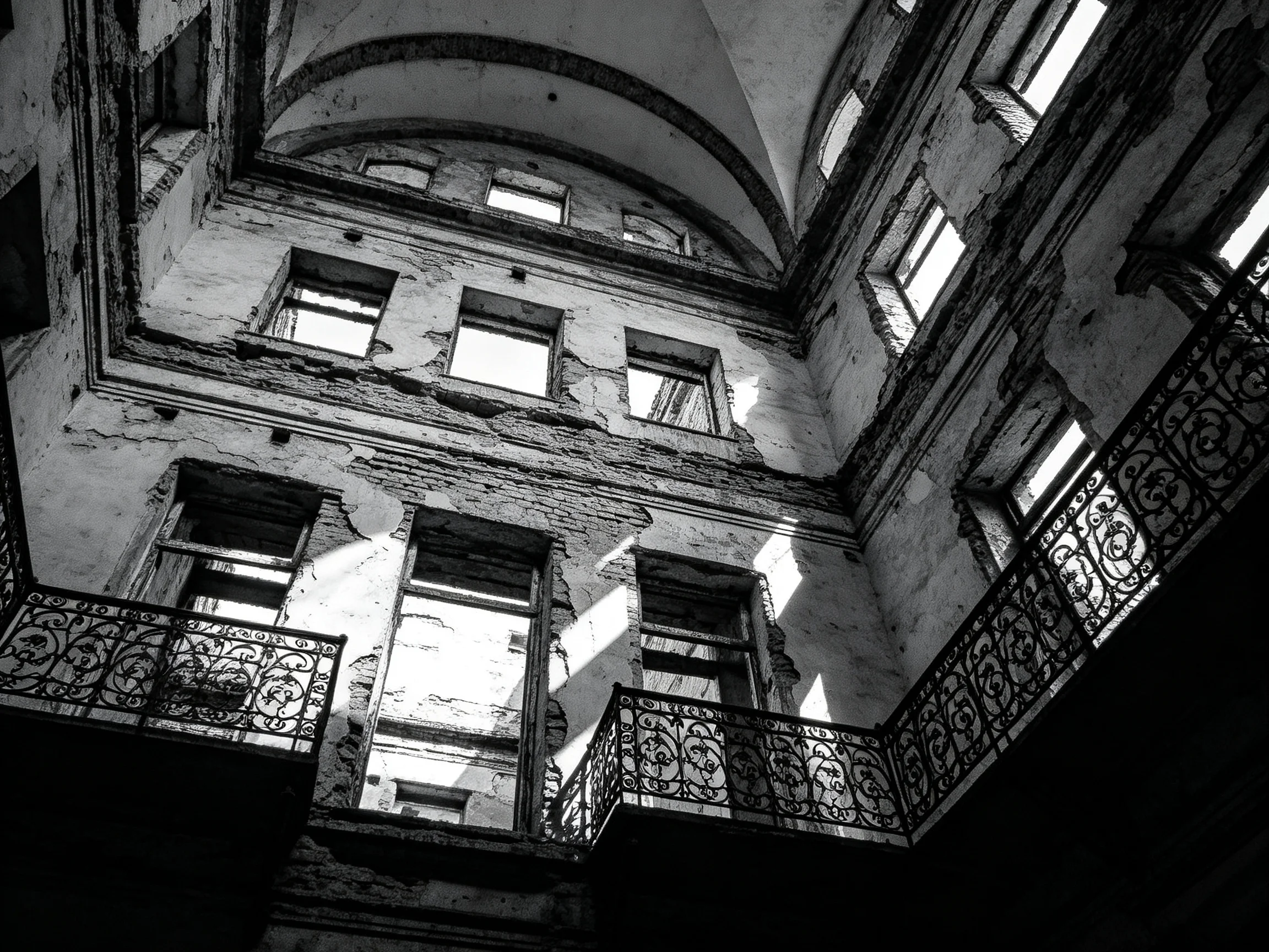 Abandoned multi-story building with arched ceilings and broken windows