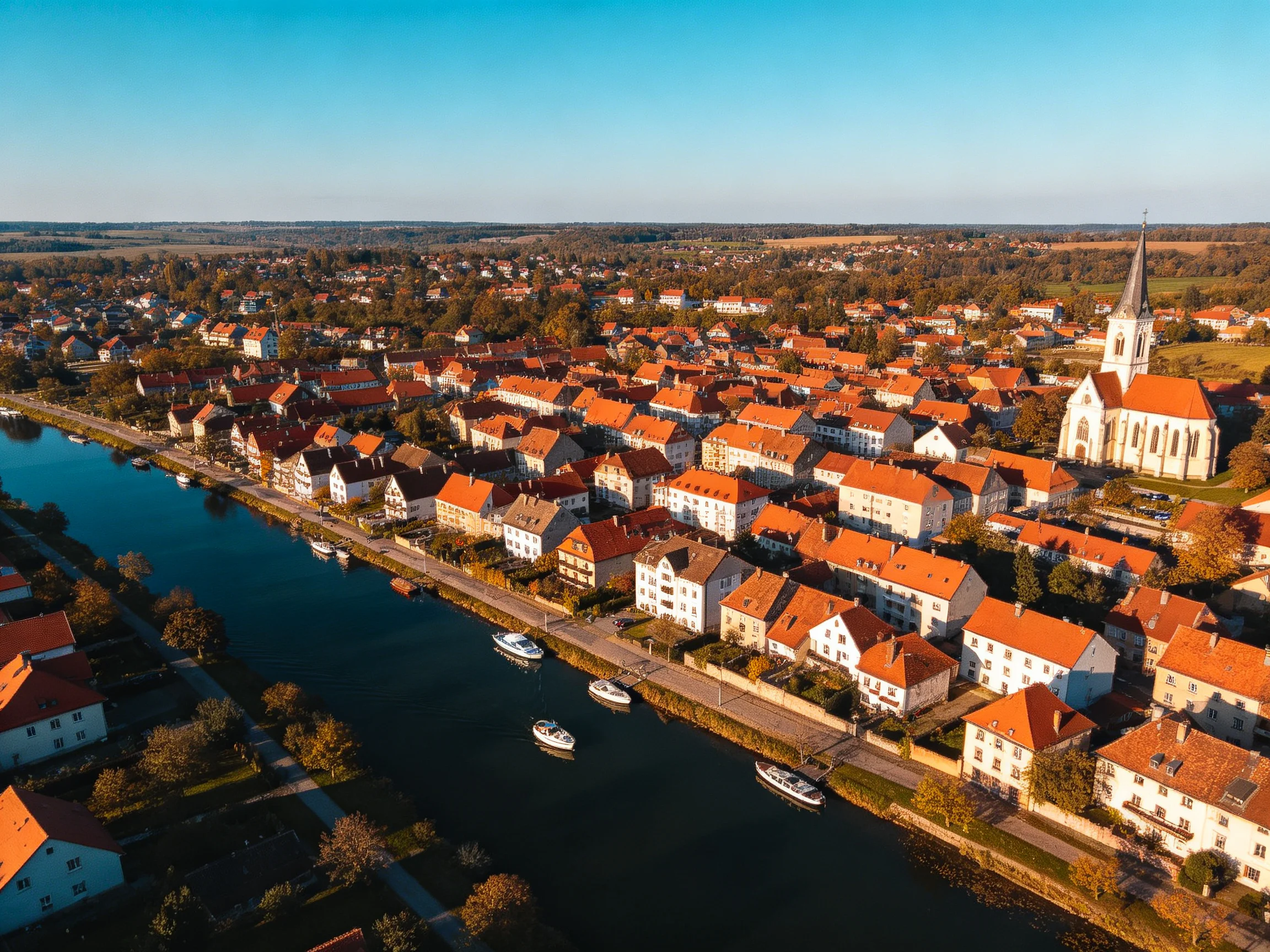 Aerial View of a Town with Orange-Roofed Buildings Along a River