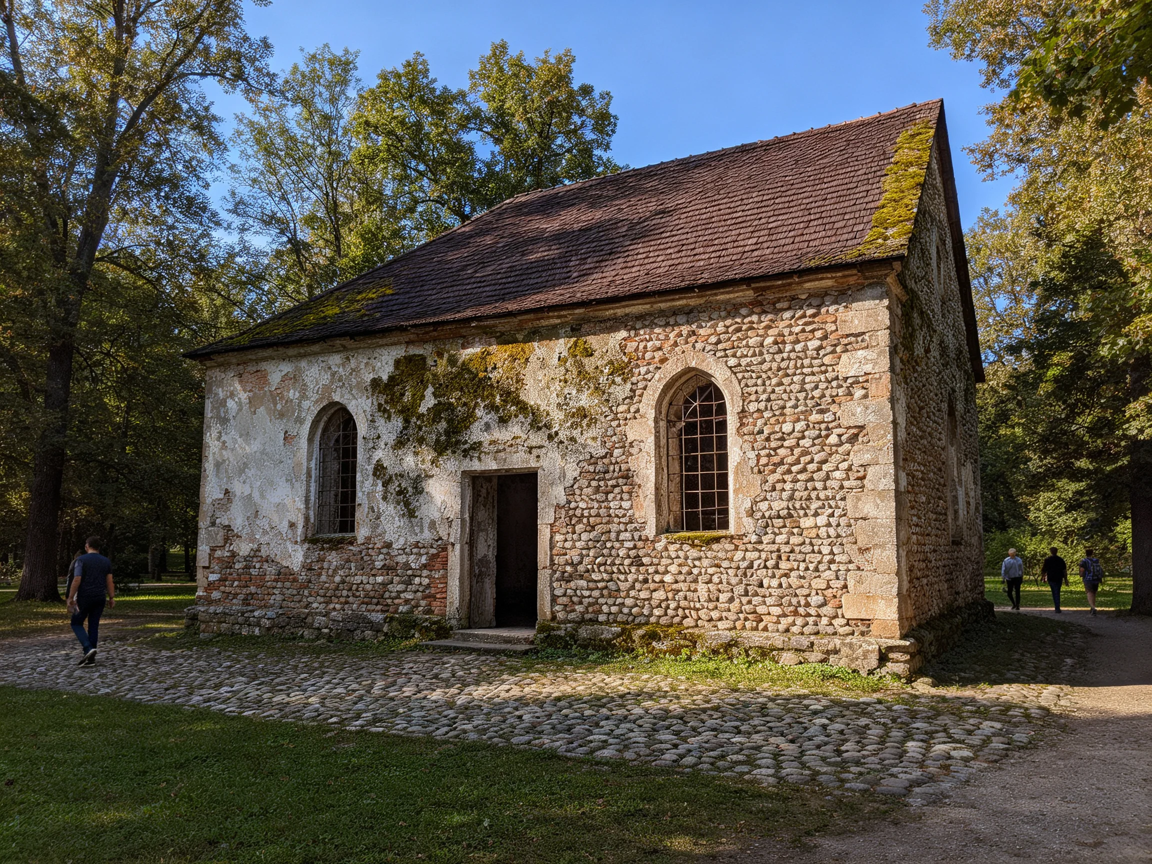 An ancient stone chapel with moss-covered roof and arched windows