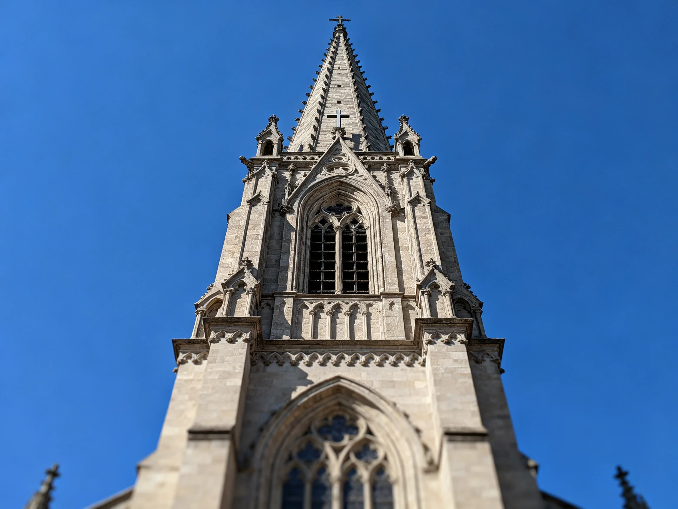 An ornate Gothic stone church tower with pointed spire