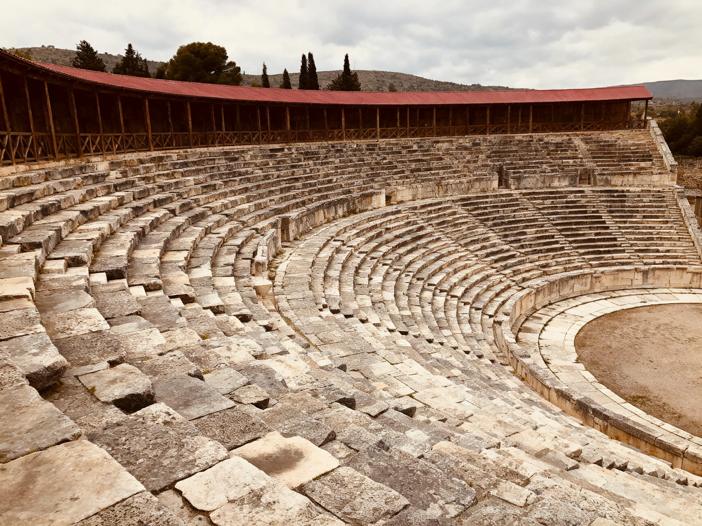 Ancient Stone Amphitheater with Red Roof and Tiered Seating