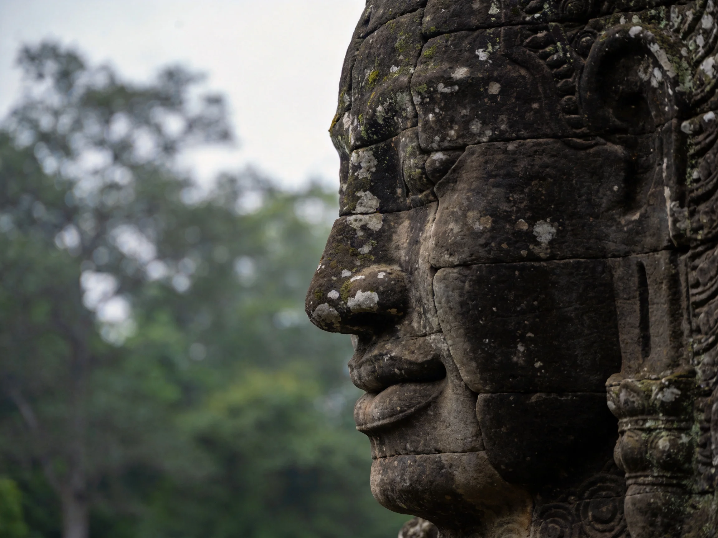 Ancient Stone Statue Face with Moss and Weathered Texture