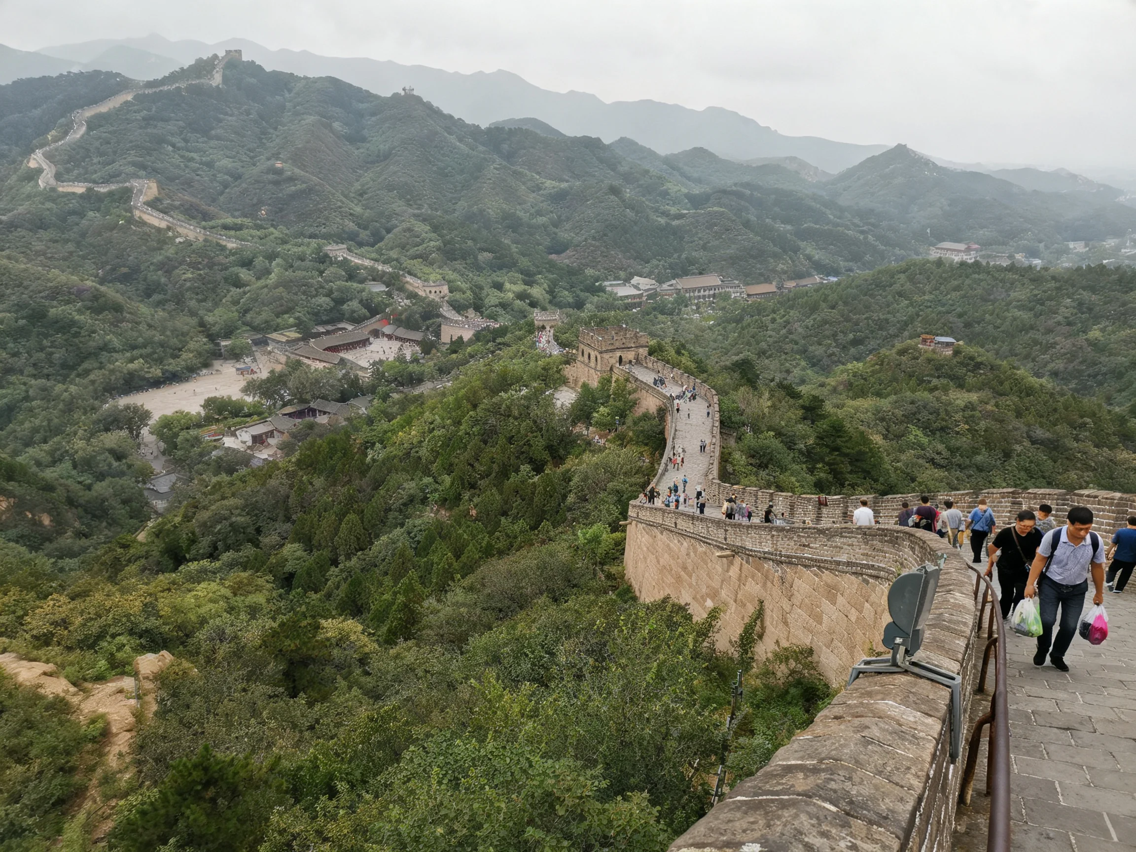 Ancient stone Great Wall winding through lush green mountainous terrain