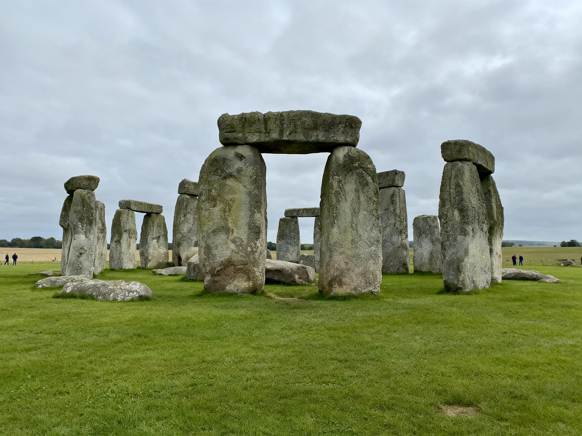 Ancient stone monument with large gray stones on lush green field