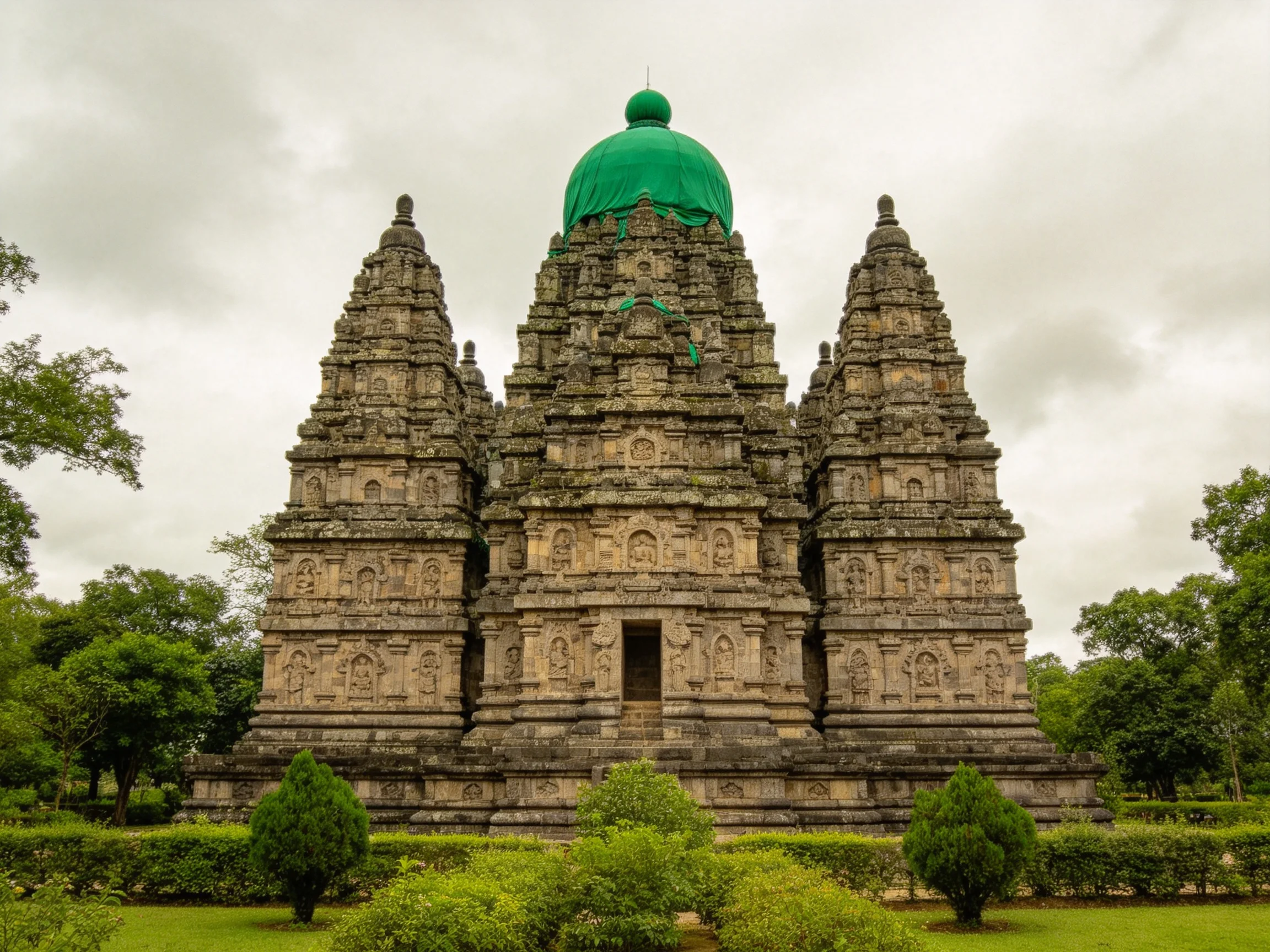 Ancient stone temple complex with three towers and green dome