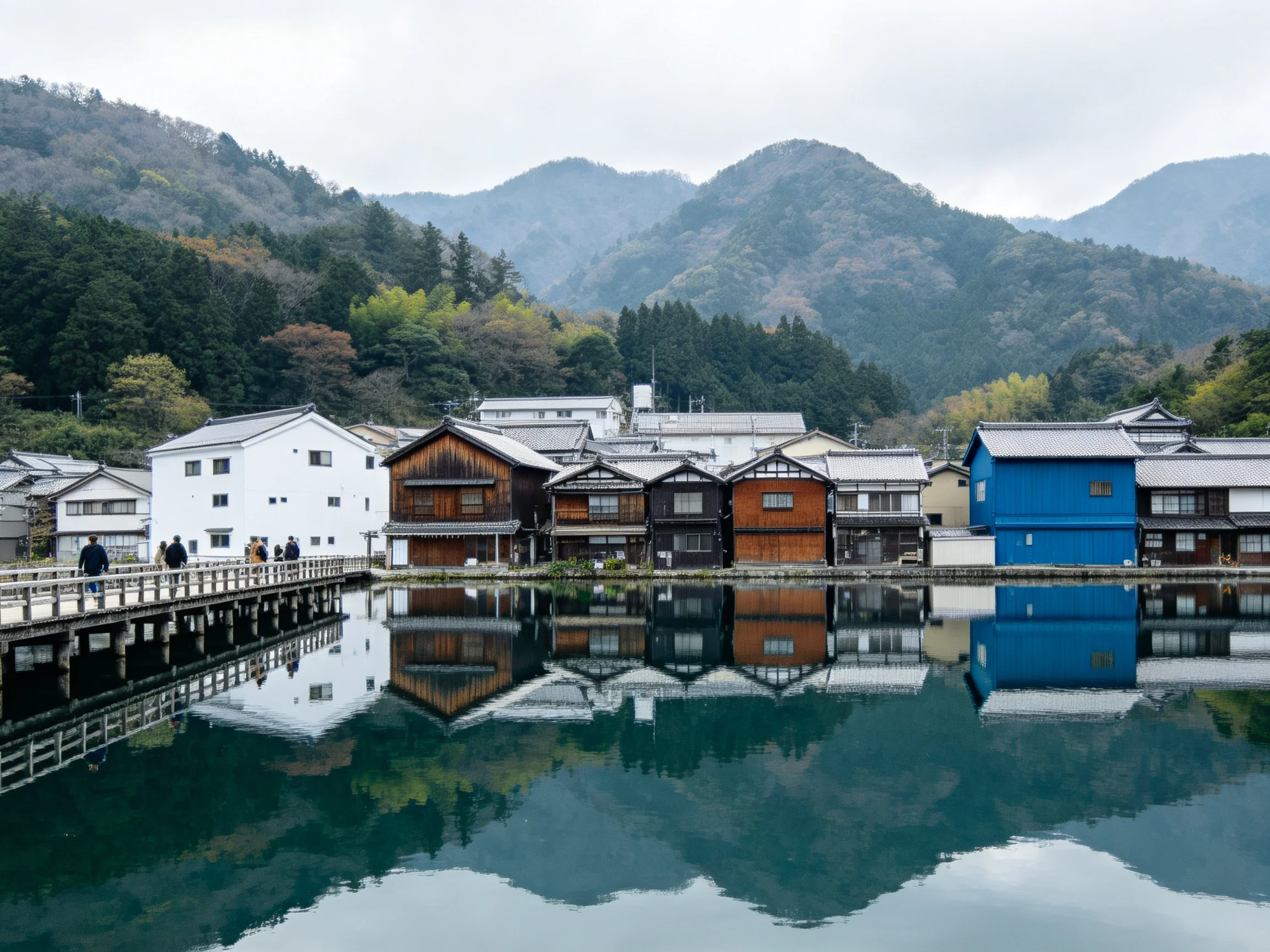 Colorful Historic Buildings Reflecting in Calm Water Near Forested Mountains