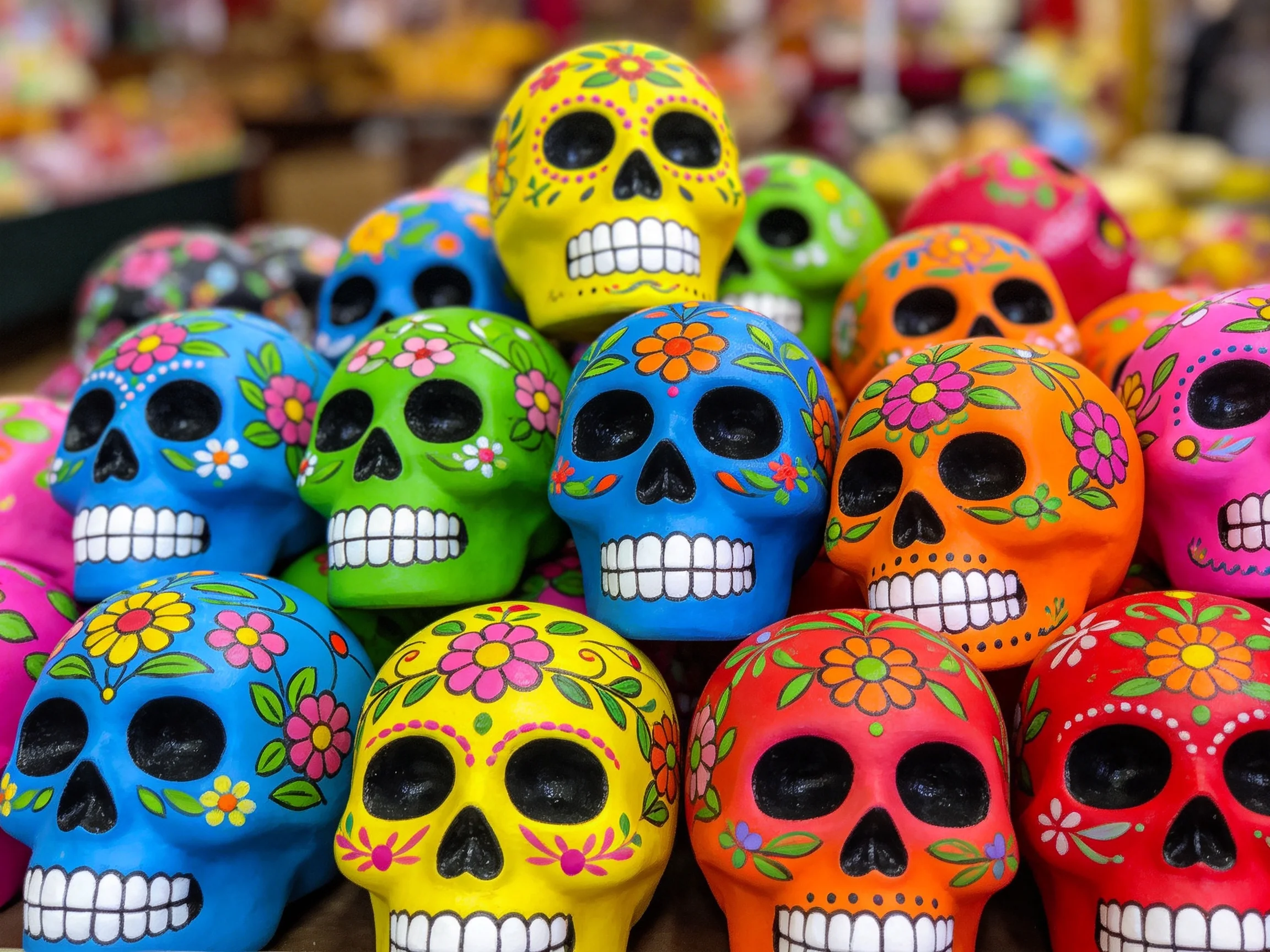 Colorful sugar skulls stacked in vibrant hues and floral designs