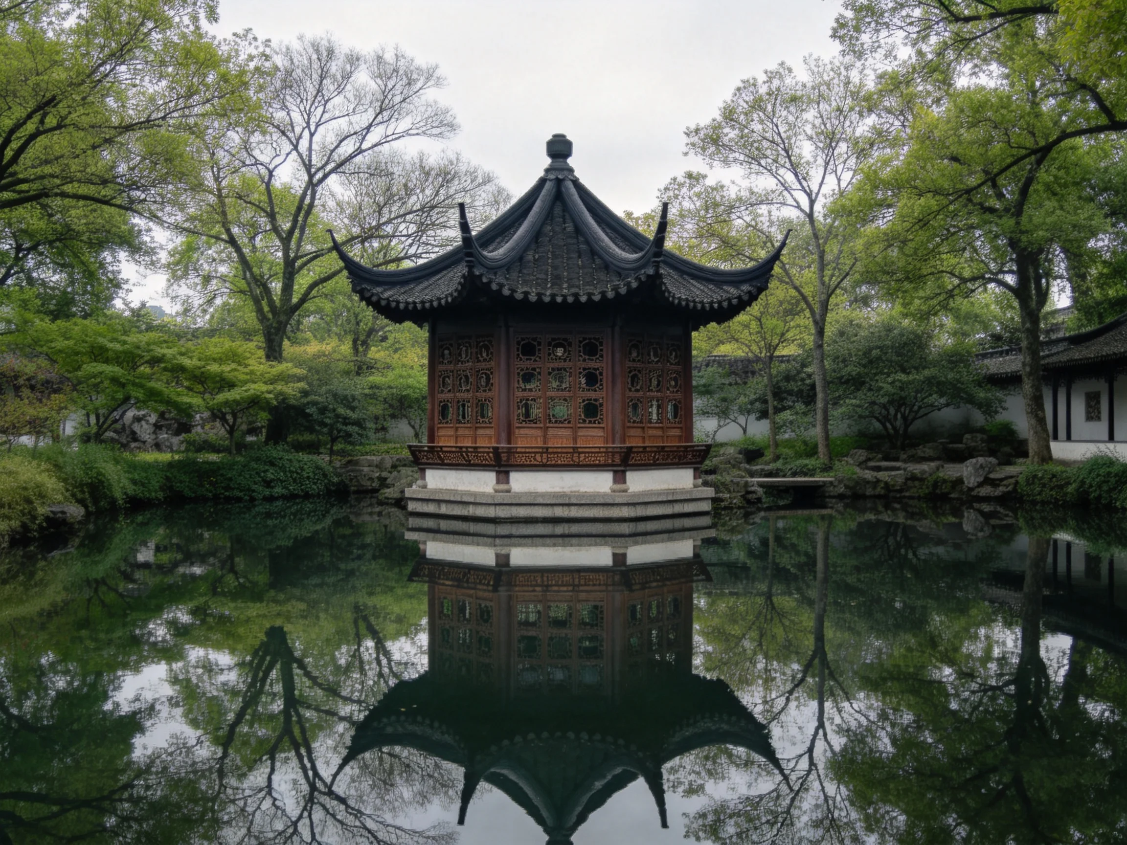 Dark-roofed traditional pavilion reflected in pond