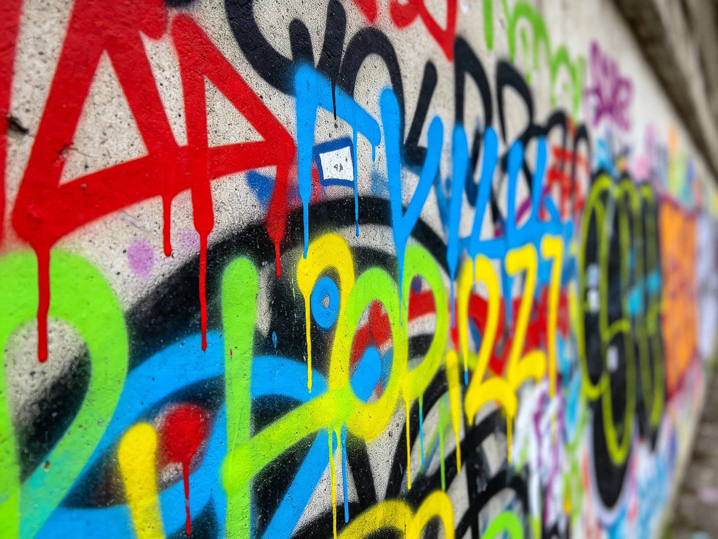 Dripping multicolor graffiti decorates a concrete wall