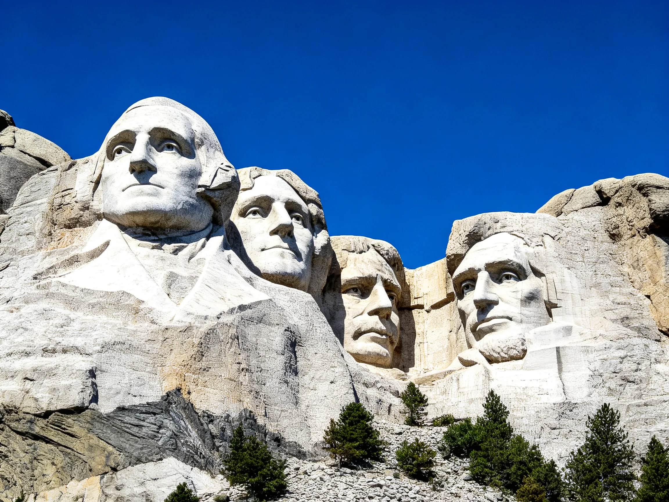 Four presidential busts carved into gray stone beneath a clear blue sky