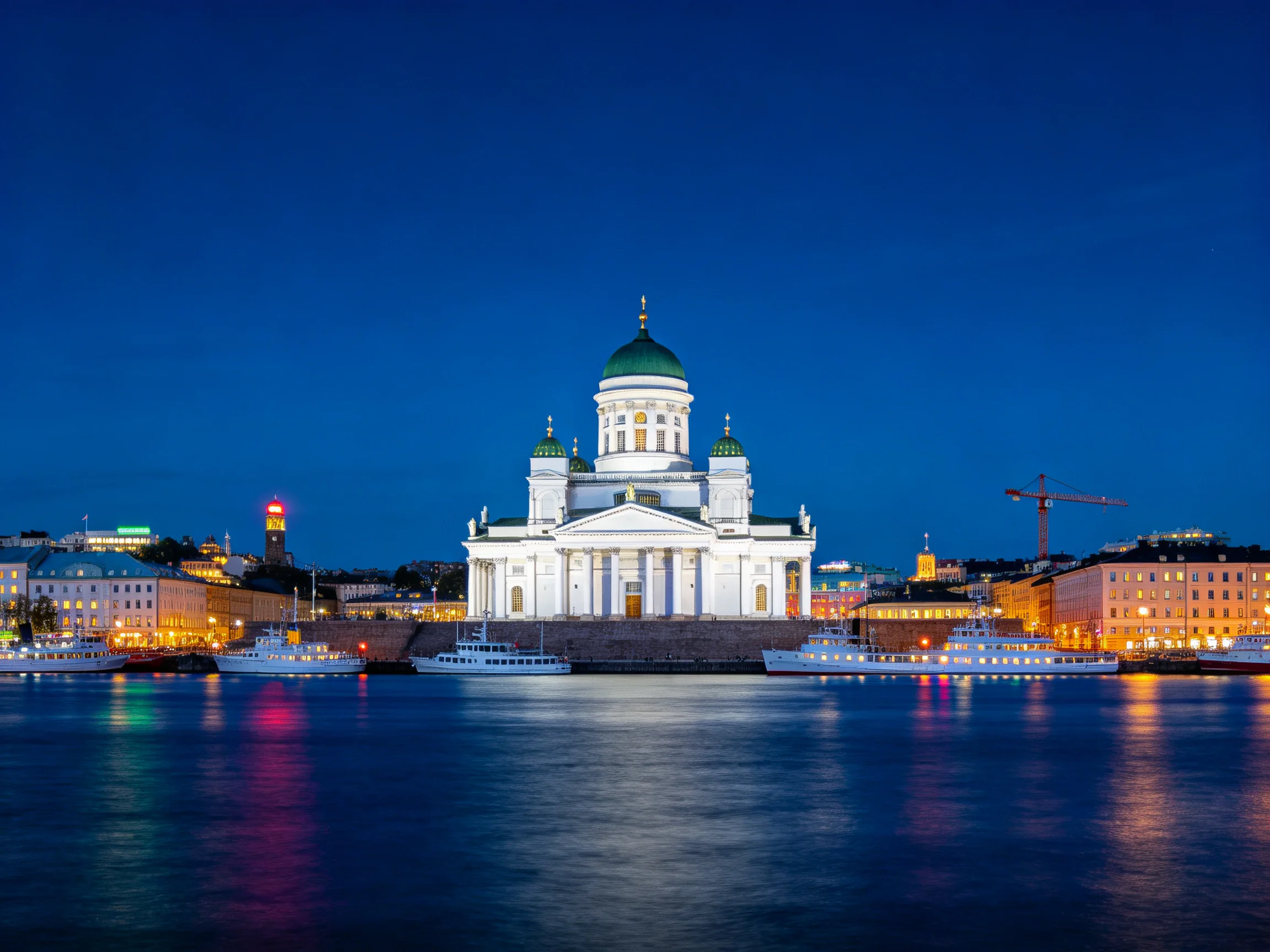 Helsinki Cathedral Illuminated at Dusk with Waterfront Boats