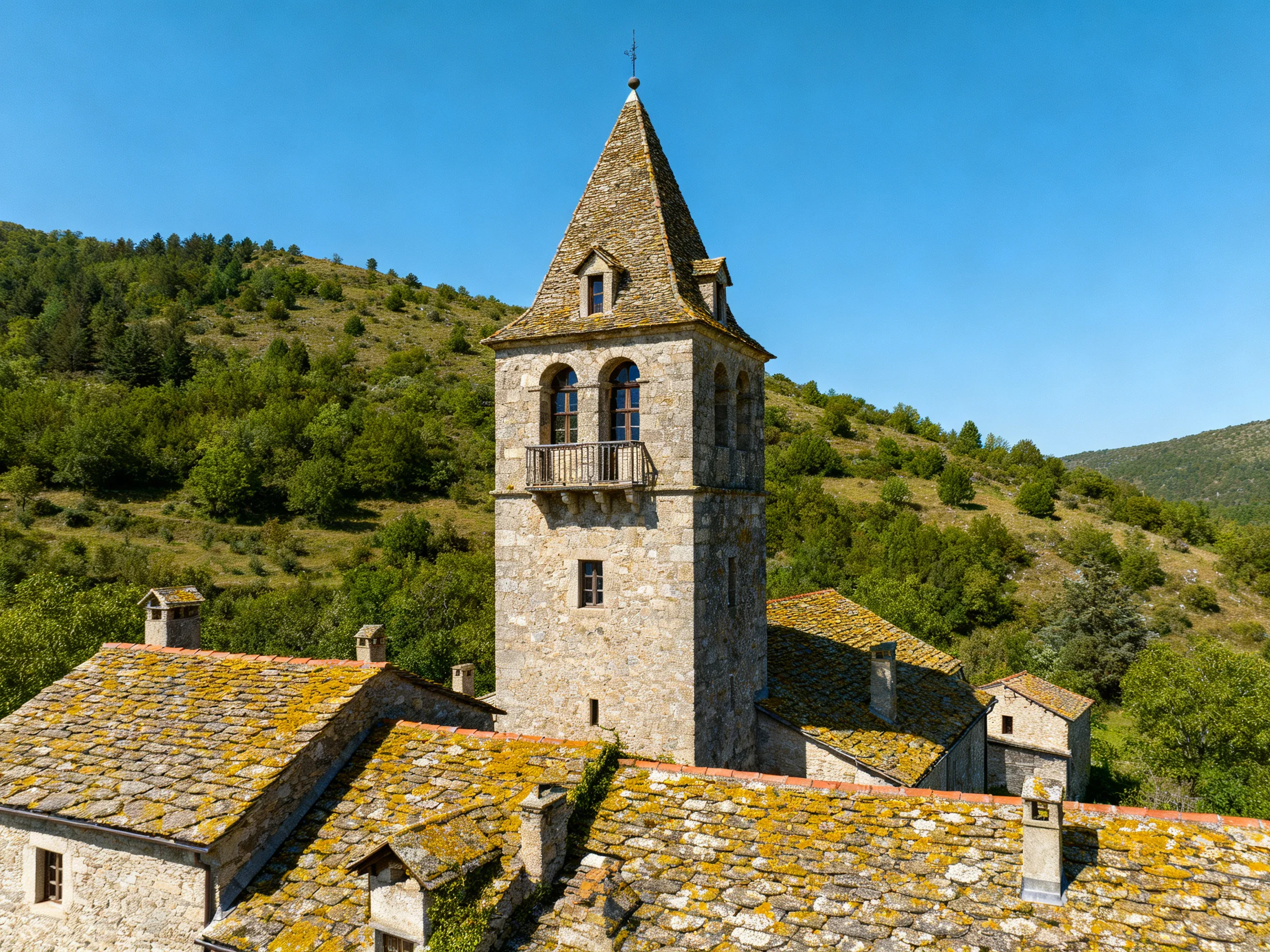 Historic Stone Tower with Moss-Covered Roofs Near Green Hills
