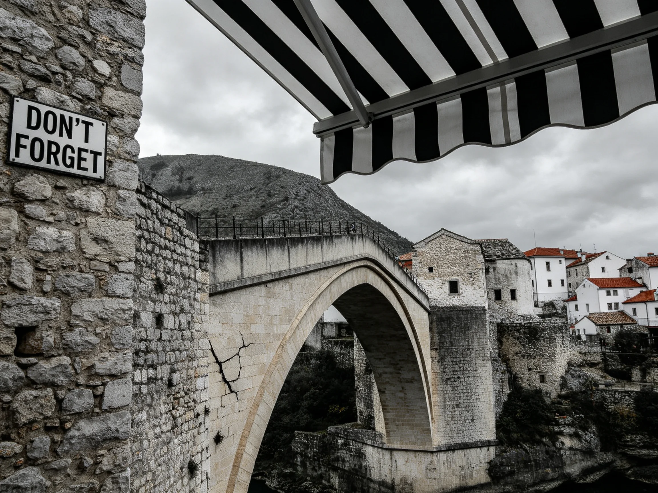 Historic stone arch bridge with black-and-white awning near white buildings
