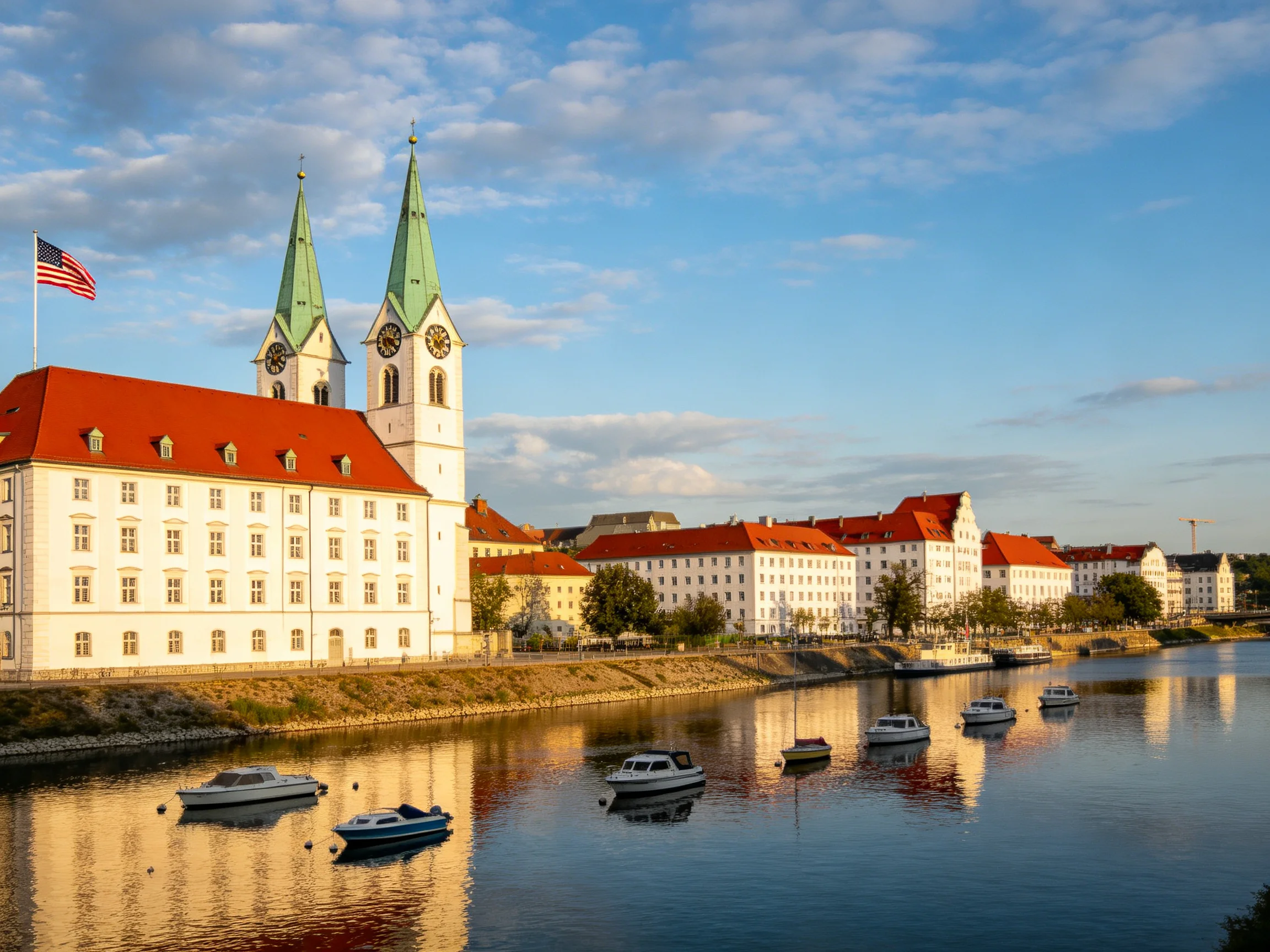 Historic white buildings with red roofs near a calm river
