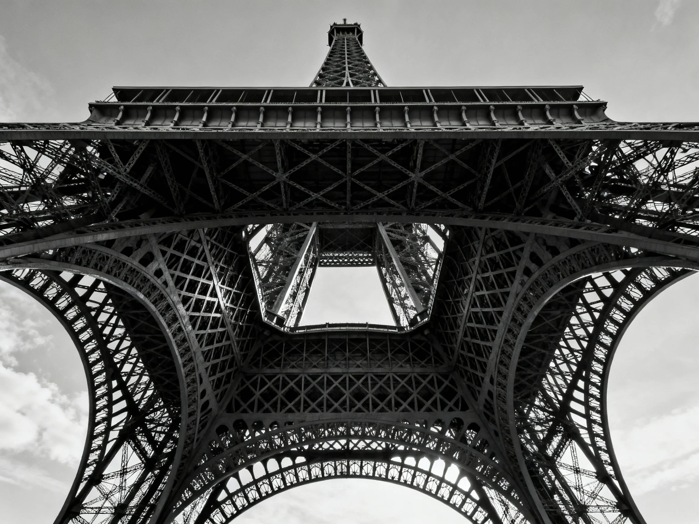 Intricate black-and-white view of the Eiffel Towers base lattice