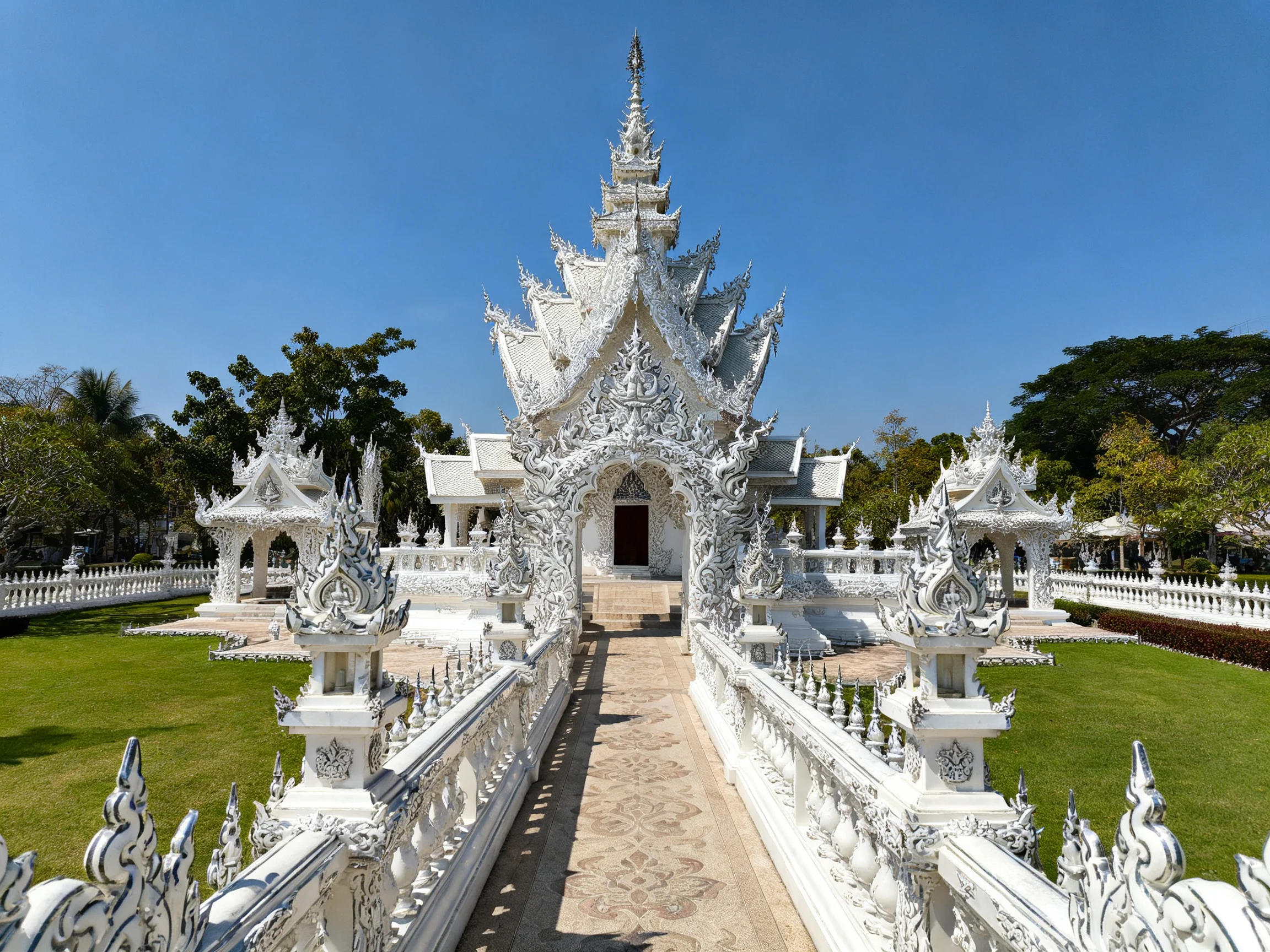 Intricate white temple complex with ornate carvings