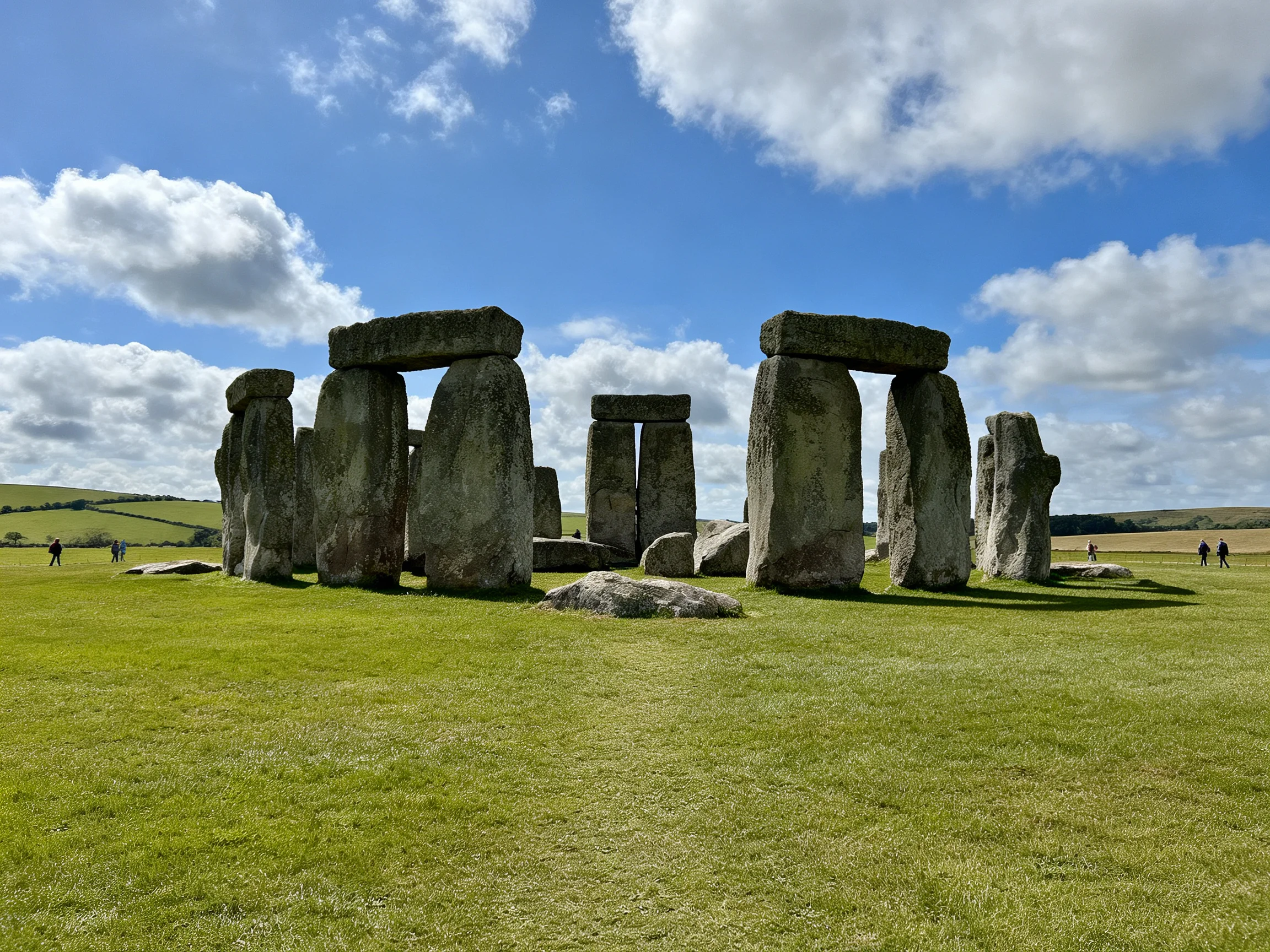 Massive ancient stone structure on vibrant green landscape under blue sky