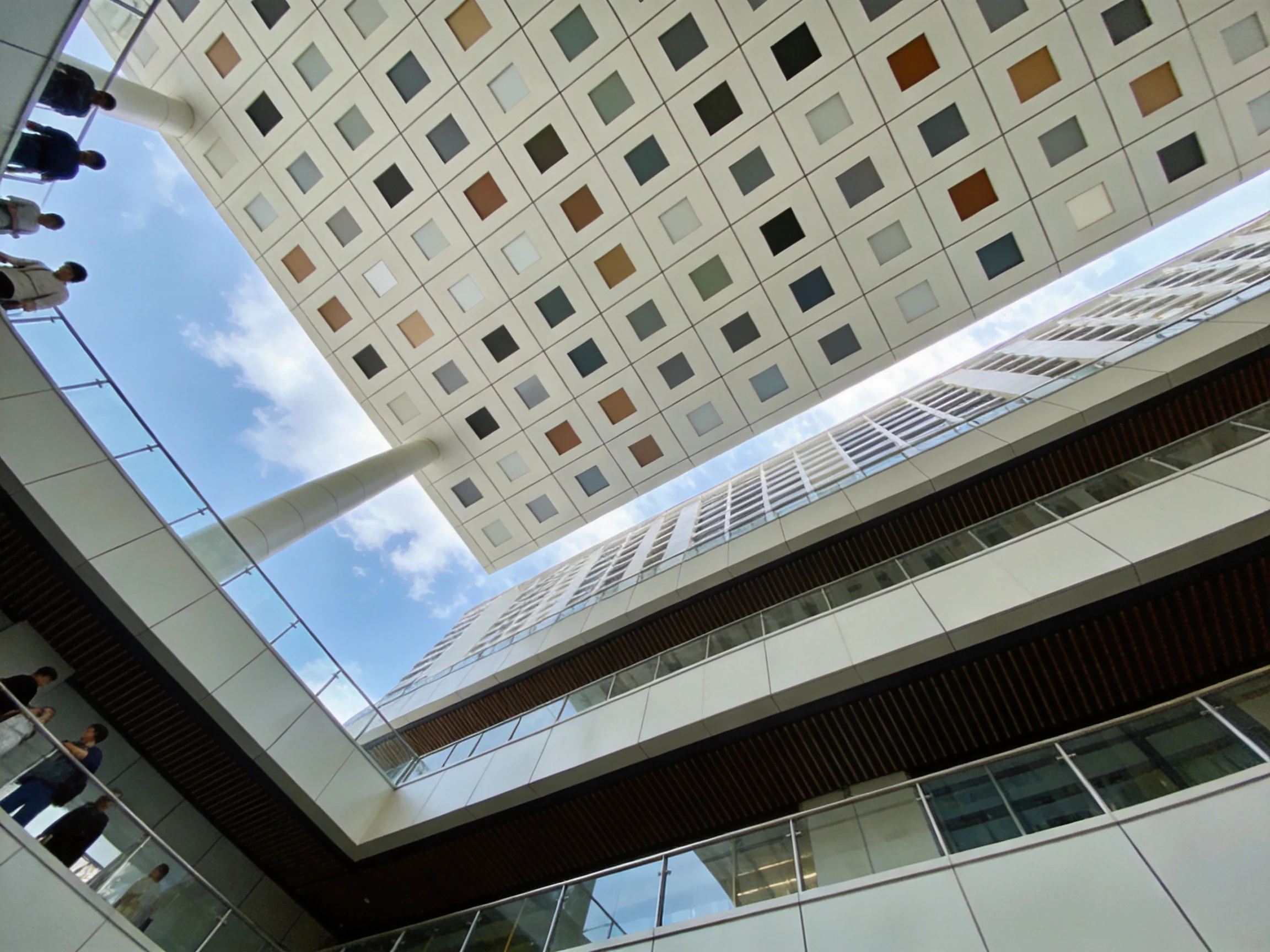 Modern courtyard with multicolored ceiling panels and glass walkways
