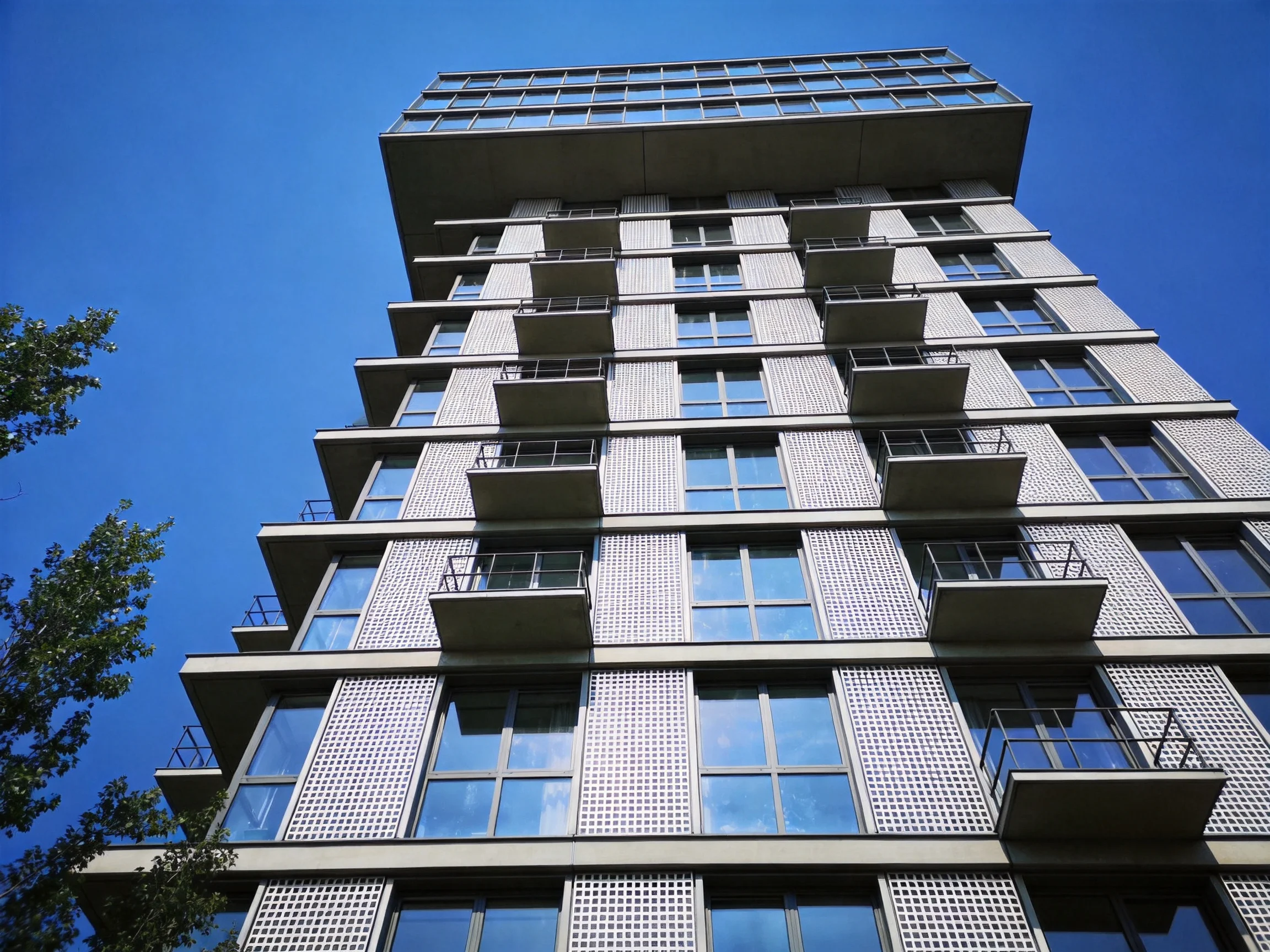 Modern high-rise building with white brick facade and glass balconies