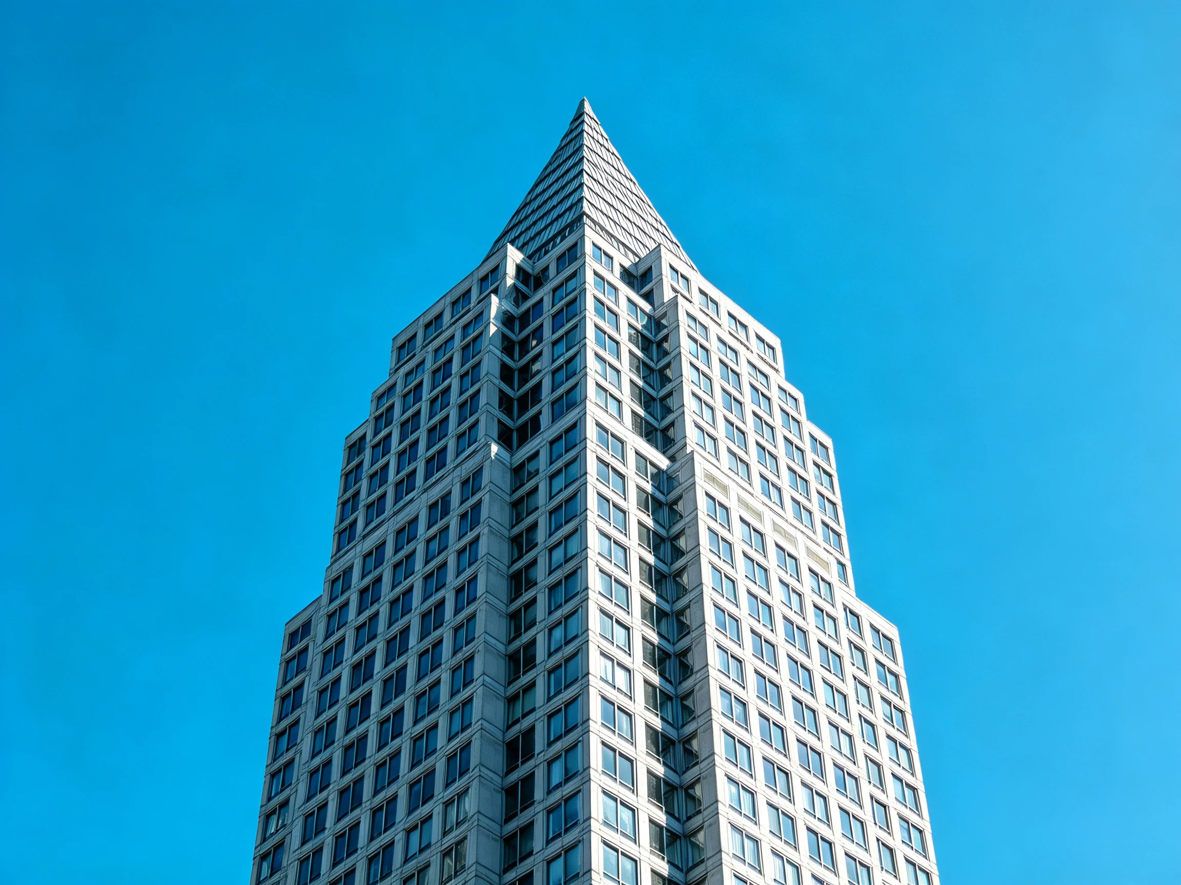 Modern skyscraper with angular design under clear blue sky