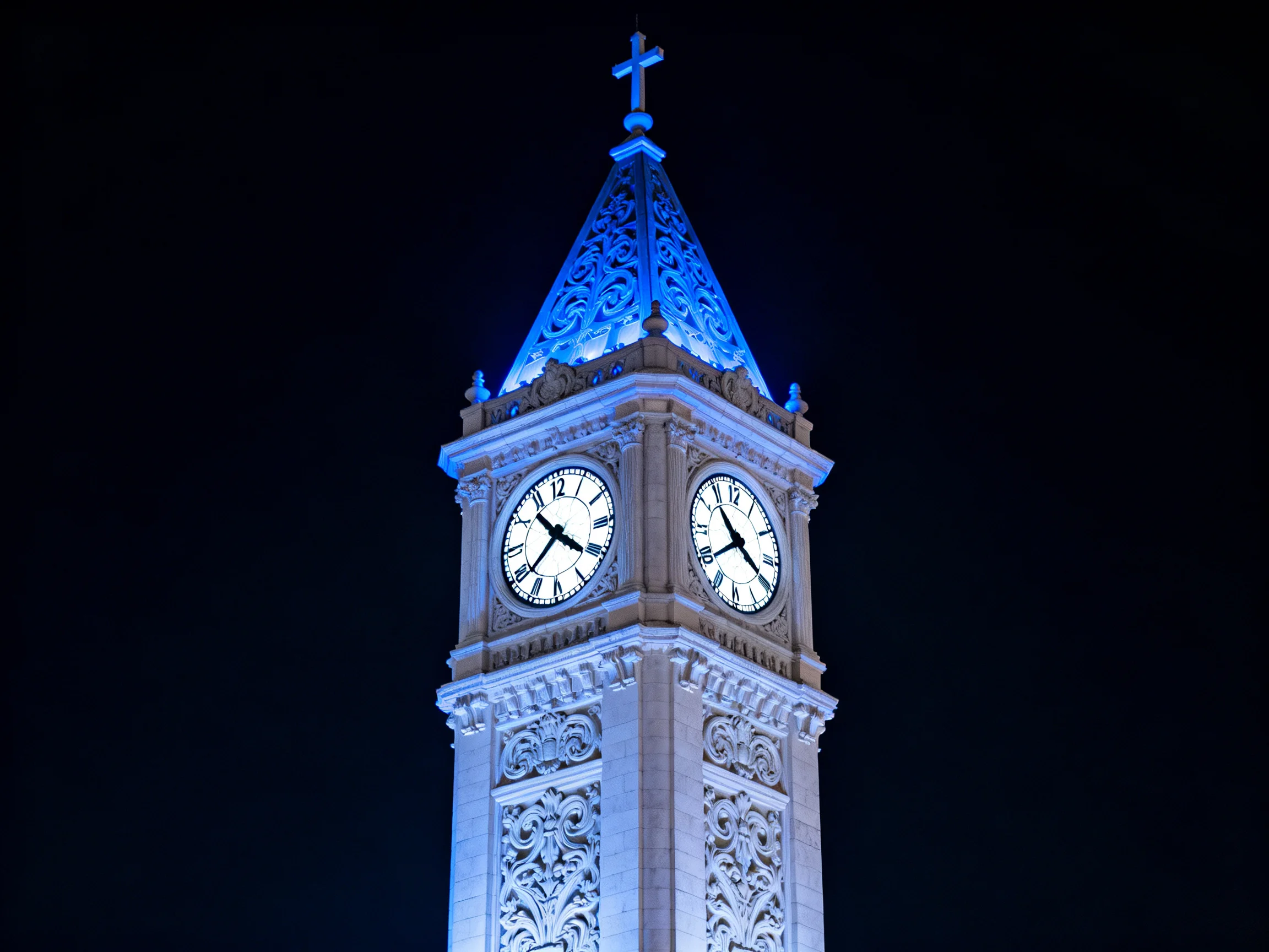 Ornate Clock Tower Illuminated in Blue at Night