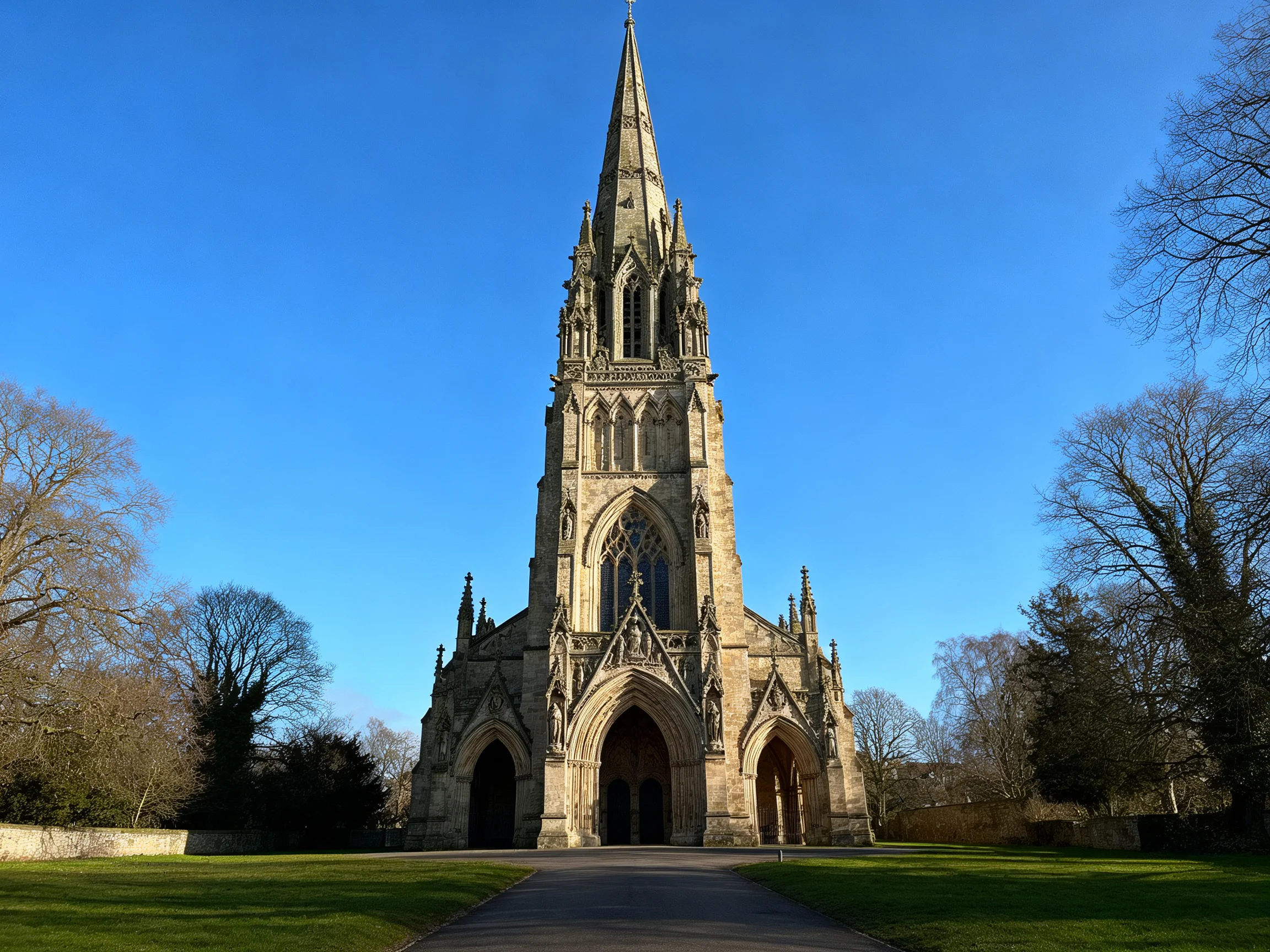 Ornate Gothic stone church tower under bright blue sky