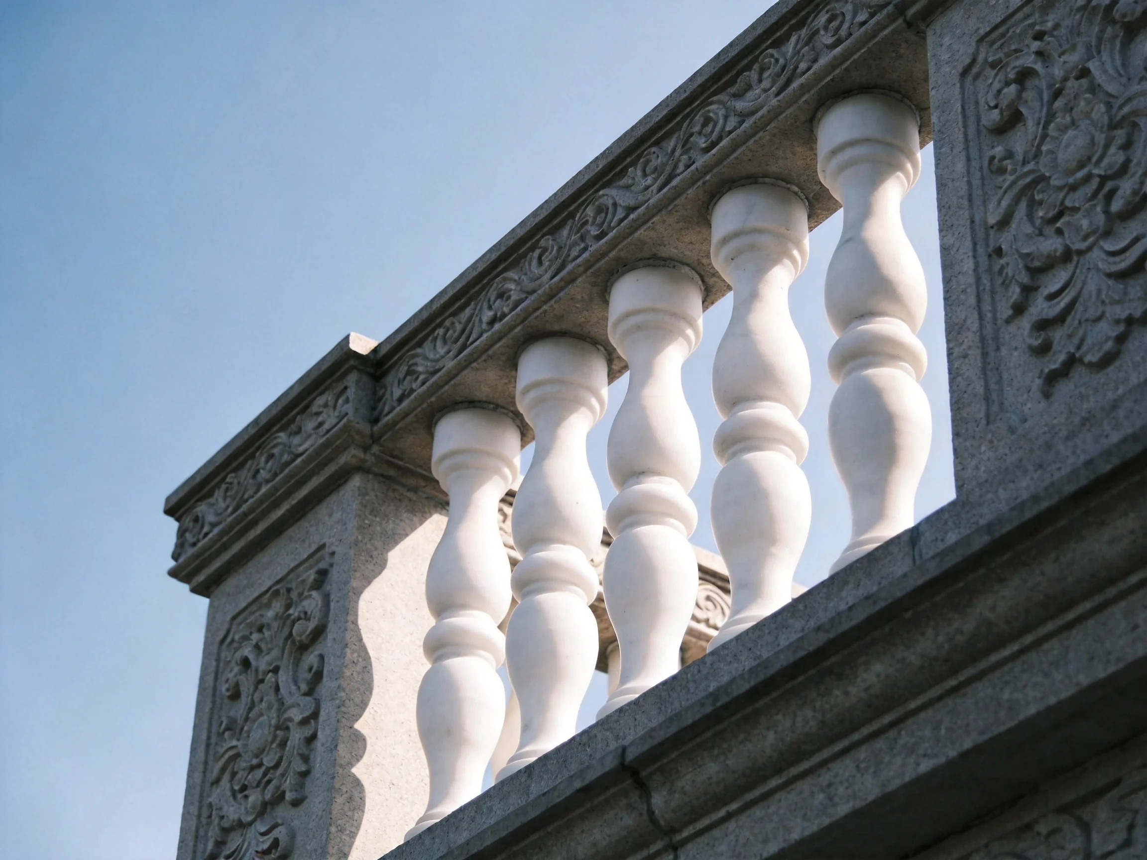 Ornate Gray Stone Railing with White Balusters and Carved Details