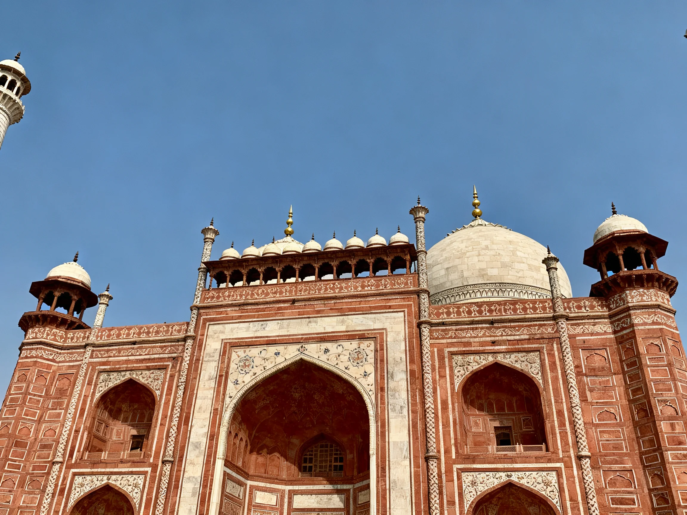 Ornate red and white historical monument with domes and arches