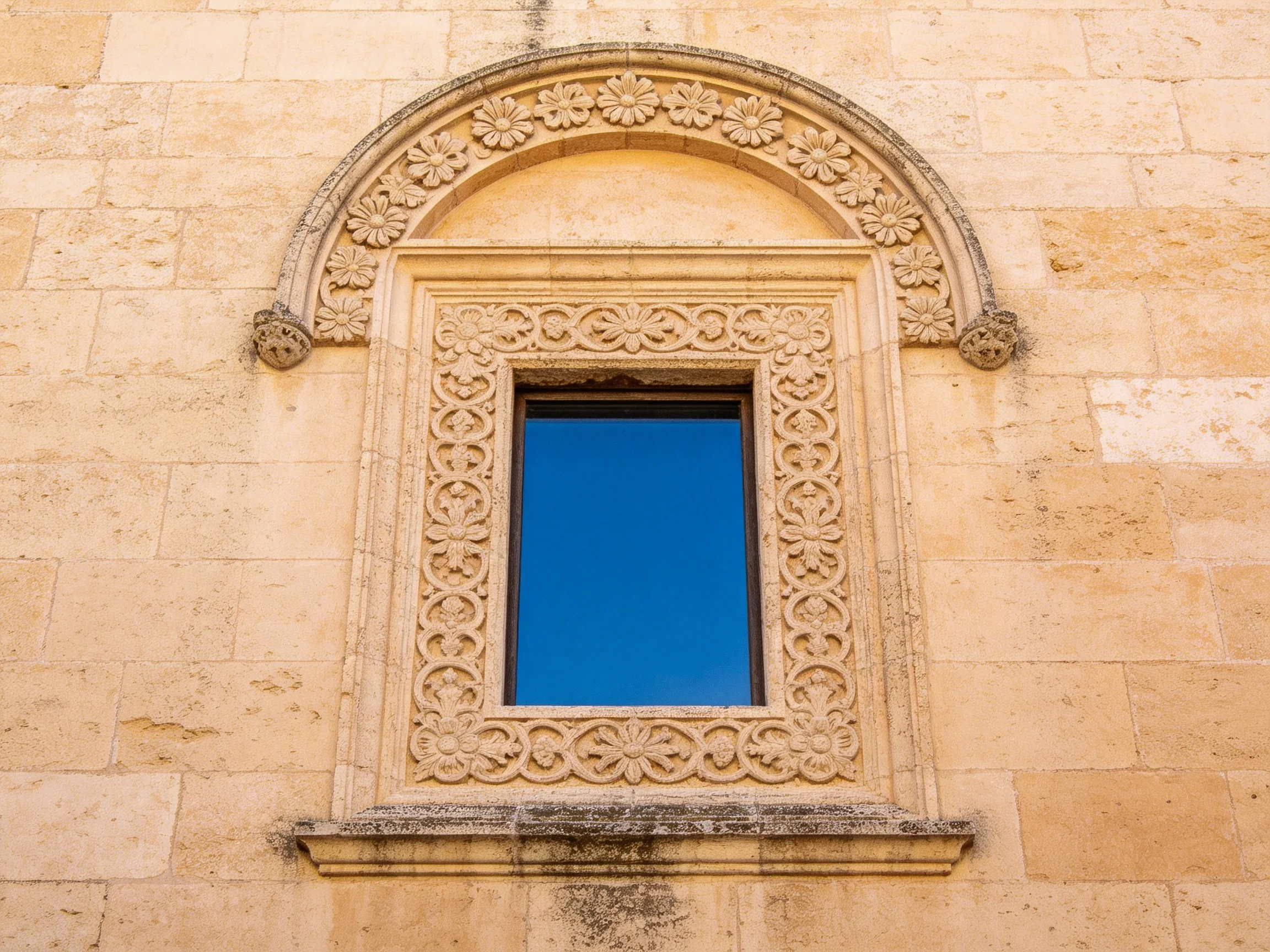 Ornately Carved Stone Window with Floral Arched Detailing