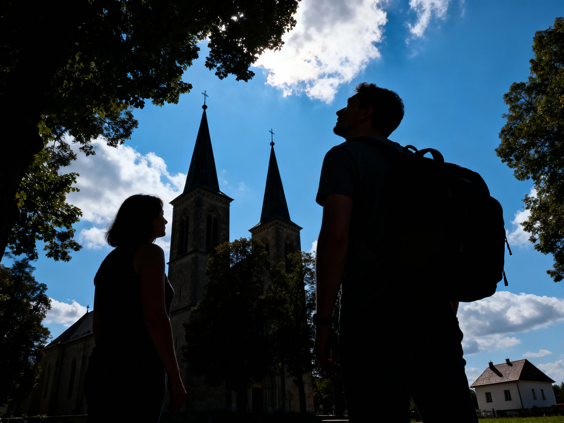Silhouetted figures near a historic church with tall spires under bright sky